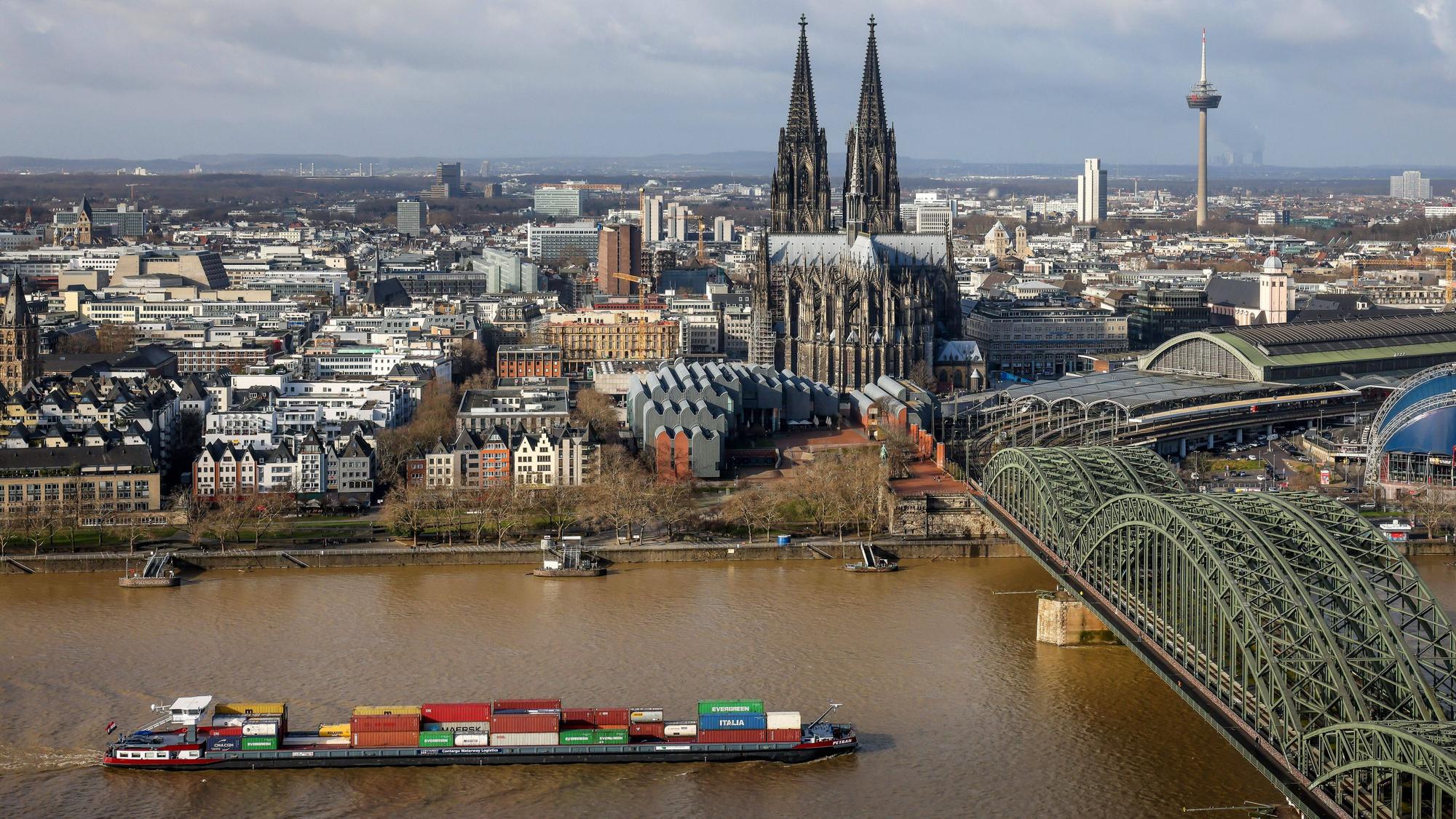 Koeln, Nordrhein-Westfalen, Deutschland - Stadtansicht mit Kölner Dom, der Hohenzollernbrücke und Containerschiff auf dem Rhein. Koeln Nordrhein-Westfalen Deutschland