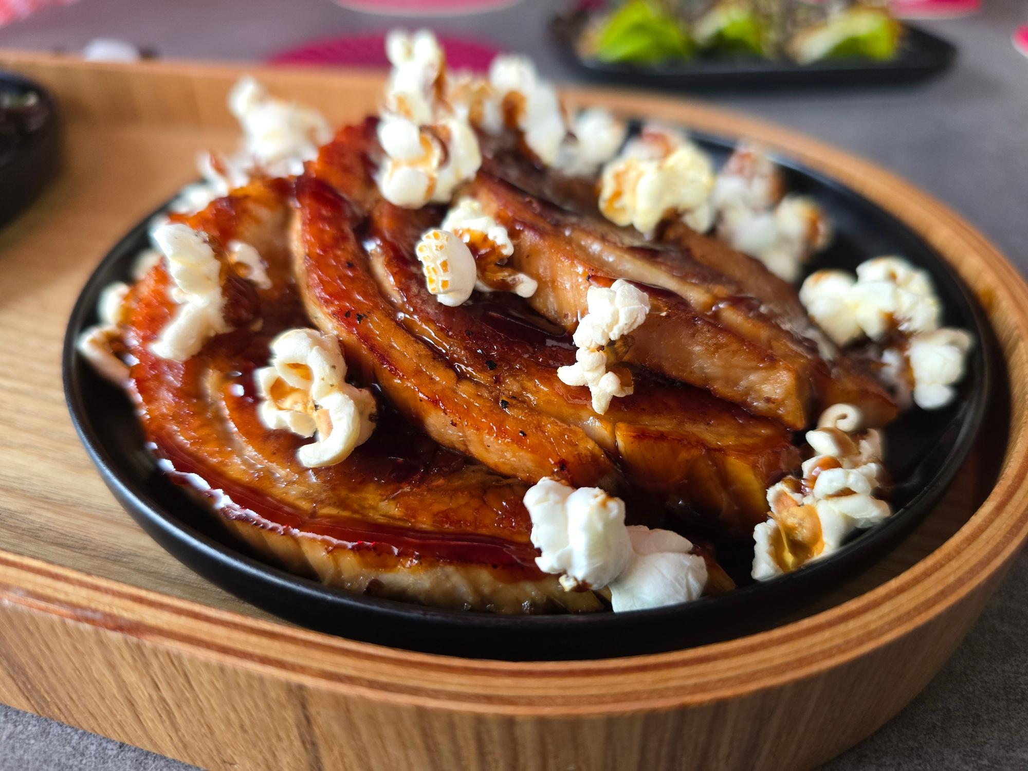 Ein Teller mit Fleischstücken und Popcorn ist zu sehen.