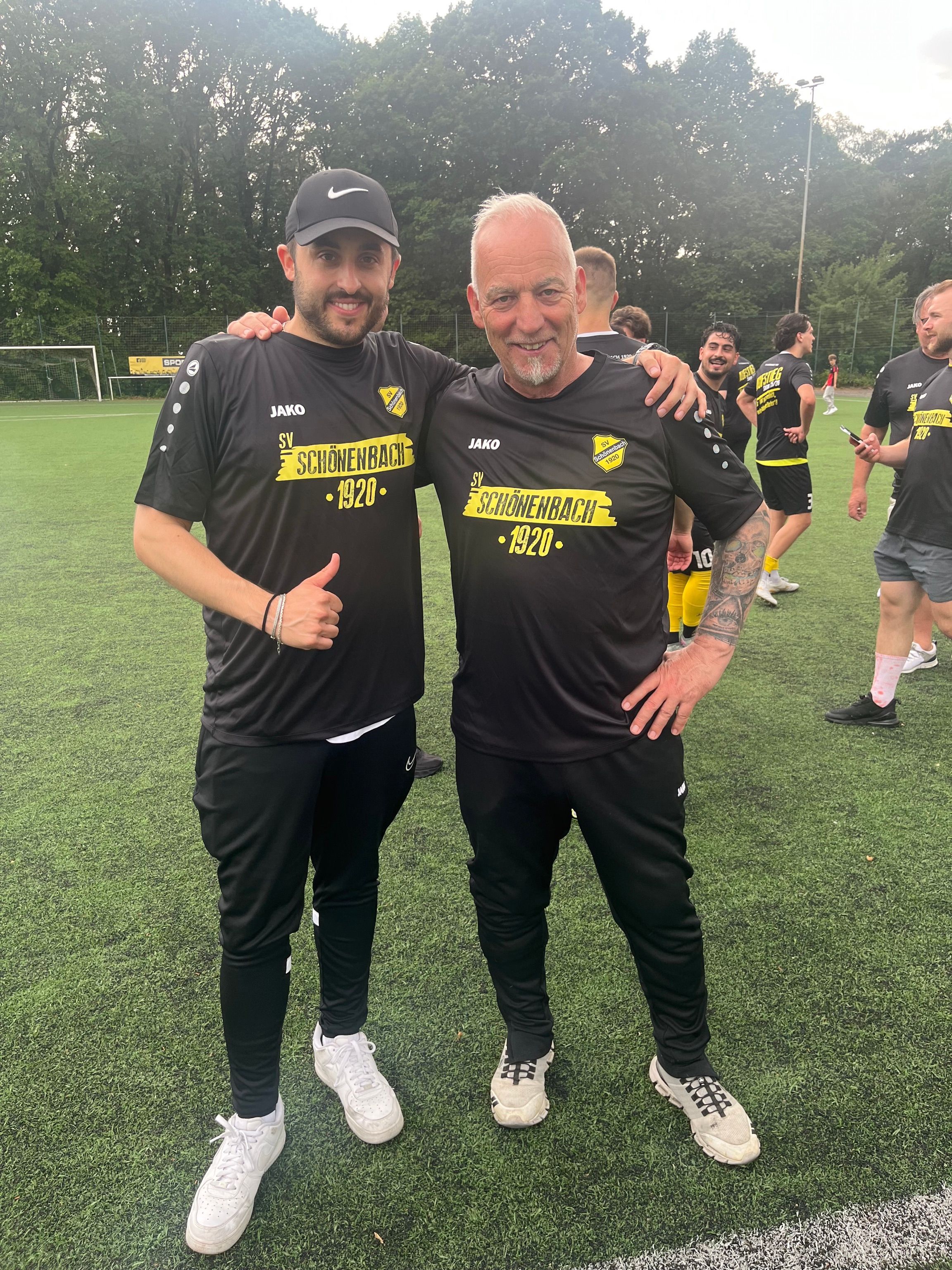 Foto von zwei Fußballtrainern, die sich umarmen.