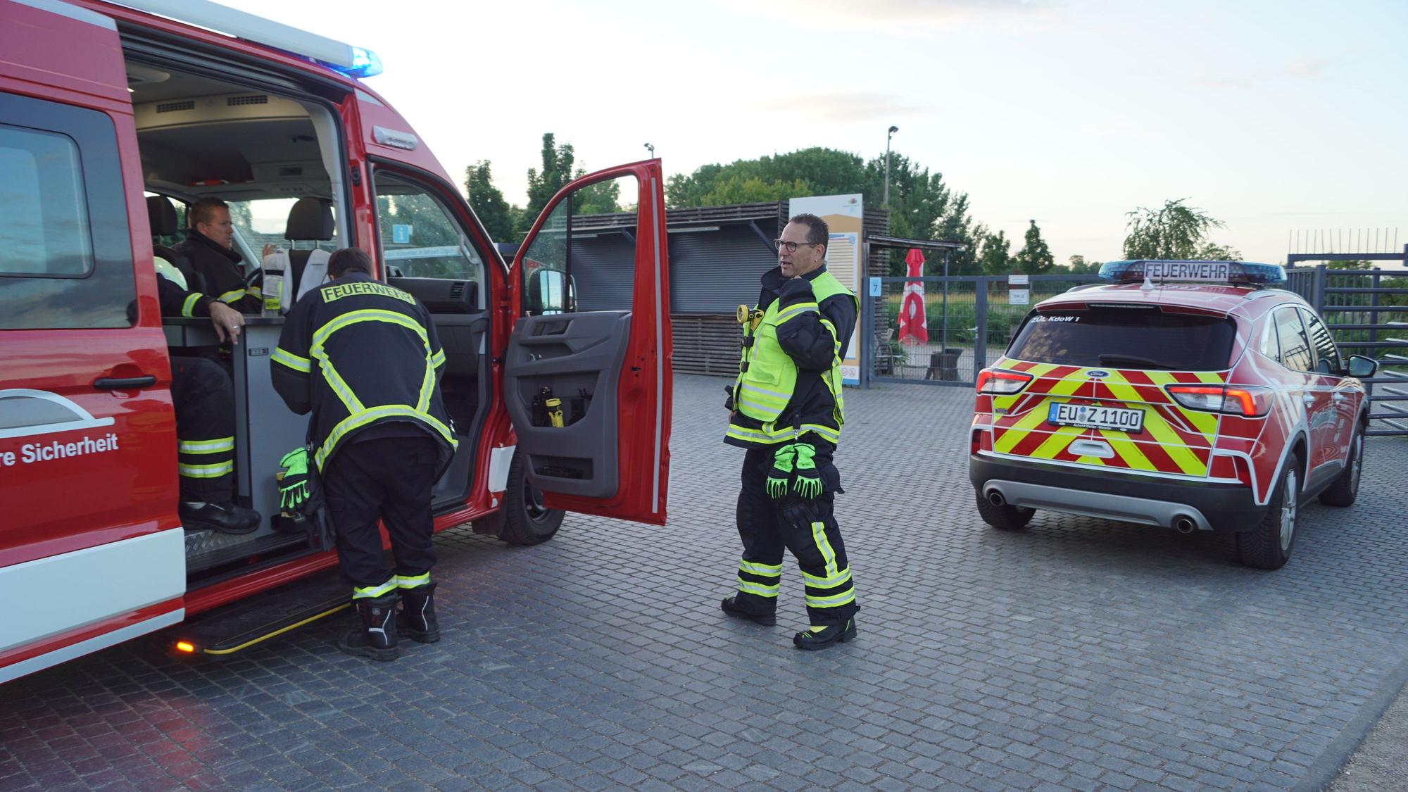 Einsatzkräfte der Feuerwehr Zülpich stehen an zwei Fahrzeugen.