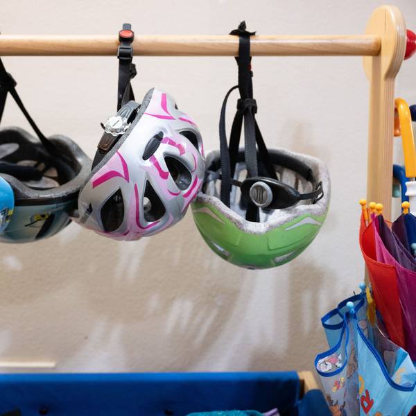 Fahrradhelme hängen in einer Garderobe in einer Kita. (Symbolbild)