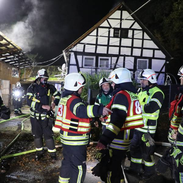 Feuerwehrleute sind bei einem Brand an einem Fachwerkhaus.