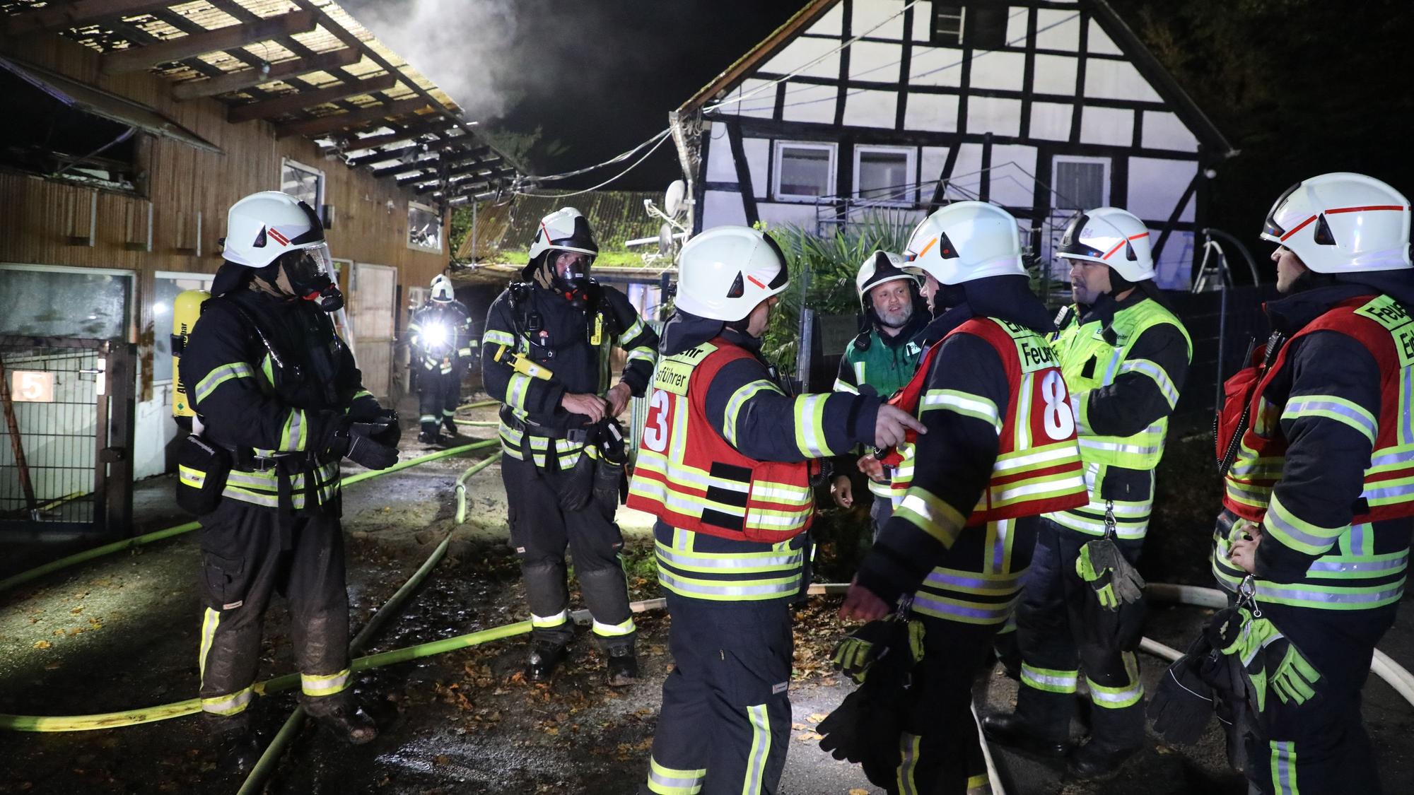Feuerwehrleute sind bei einem Brand an einem Fachwerkhaus.