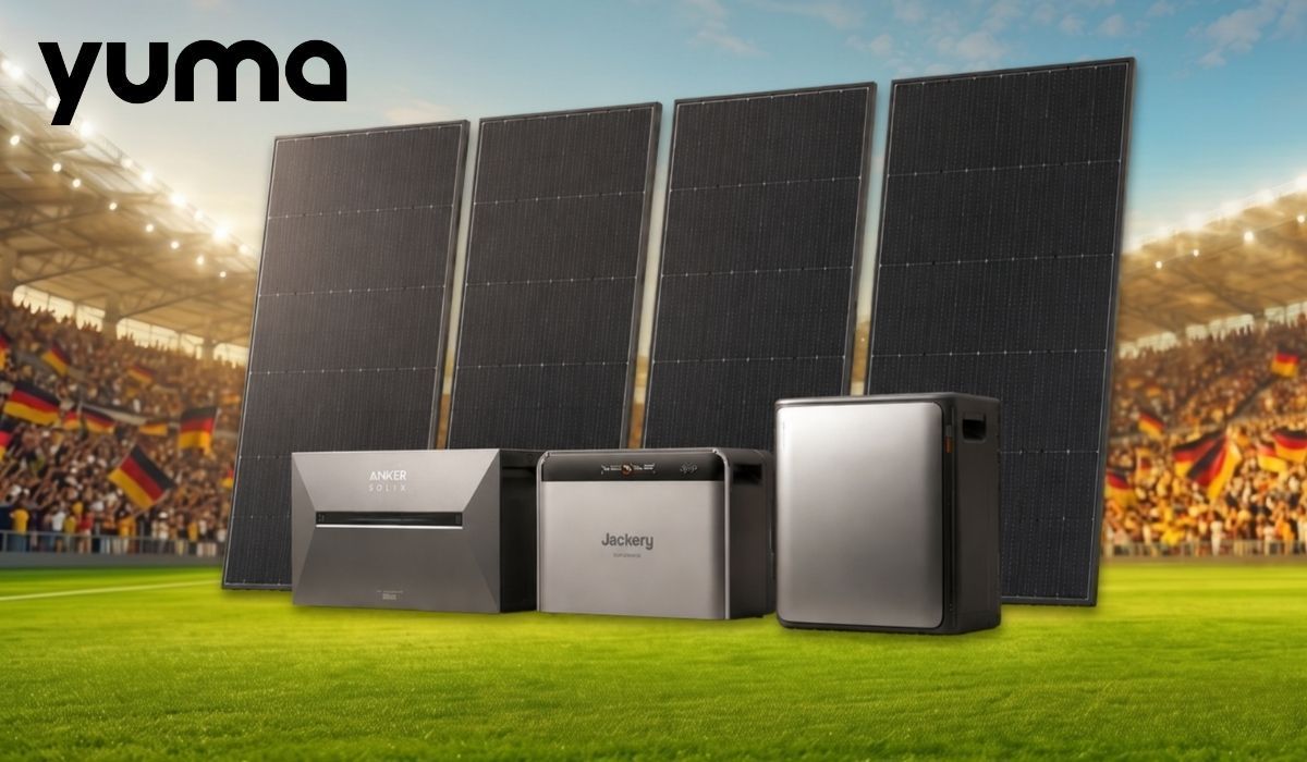 Produktgrafik von Yuma mit drei Heimspeichern der Marken Anker Solix und Jackery sowie vier aufgestellten Solarmodulen, fotografiert vor der Kulisse eines Fußballstadions mit Deutschland-Fans und Fahnen im Hintergrund. Warmes Abendlicht.