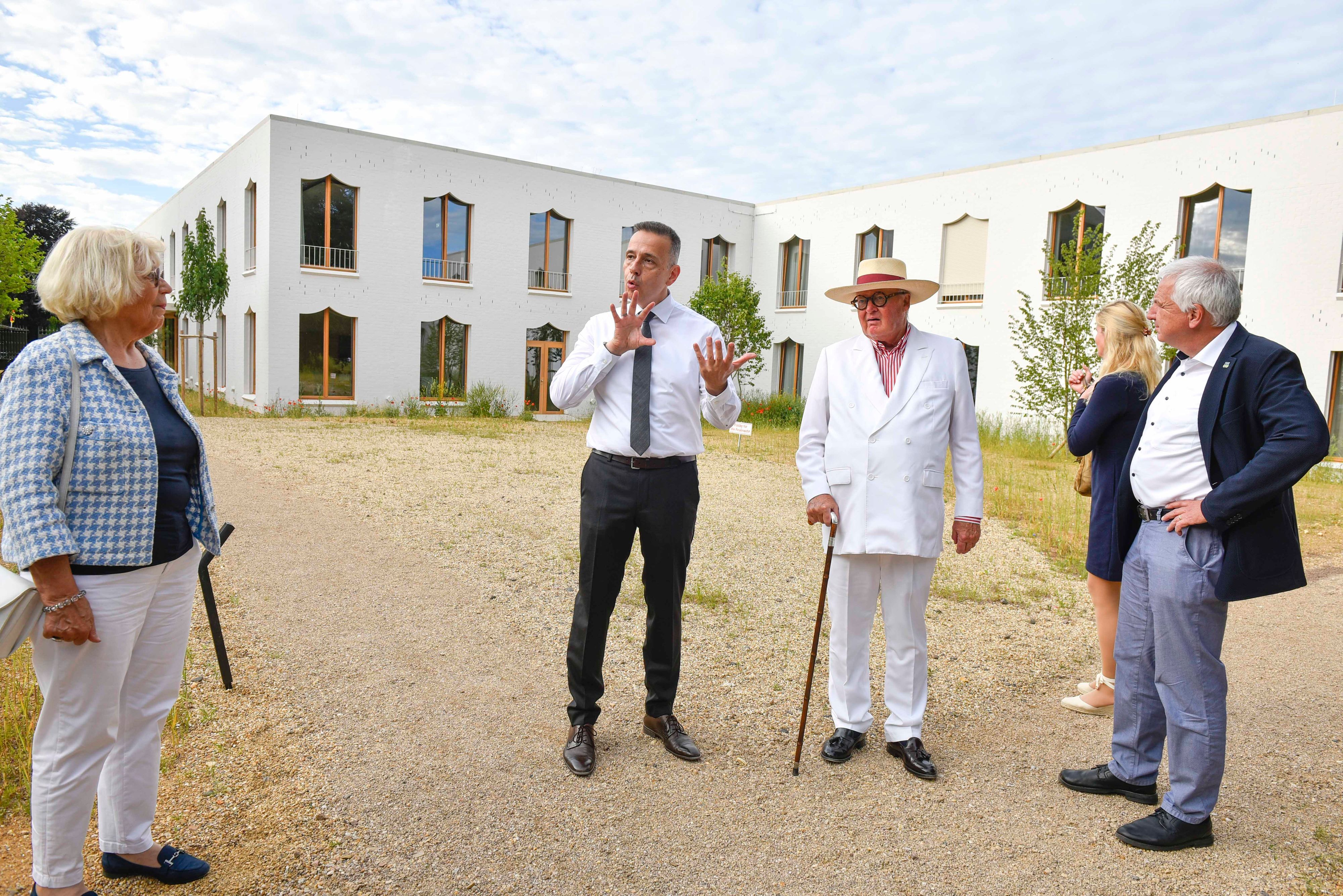 Zu sehen sind Menschen und im Hintergrund das neue Gebäude.