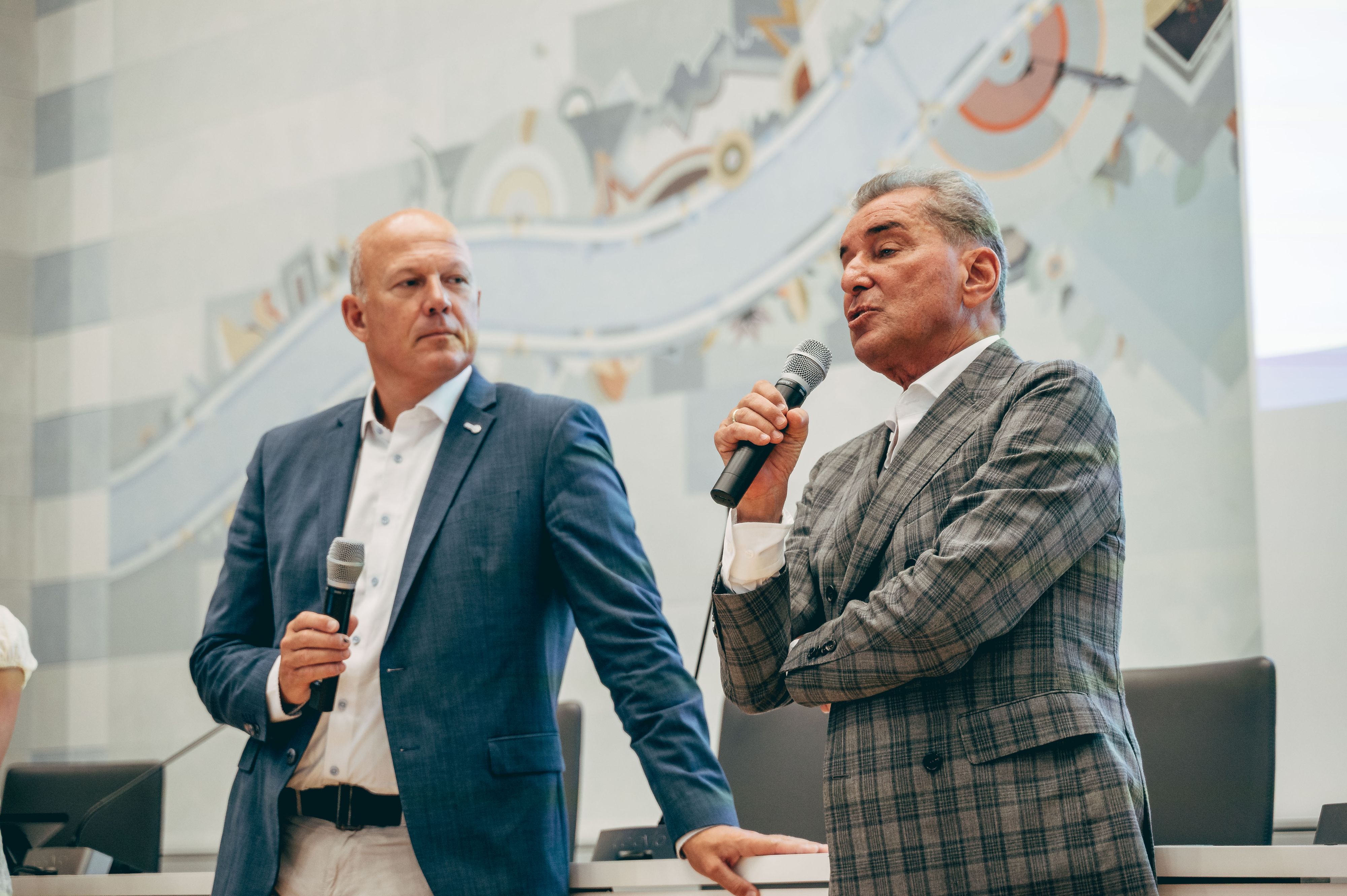 Das Bild zeigt Landrat Frank Rock und Michel Friedman. Beide halten Mikrofone. Friedman trägt ein kariertes Sakko.