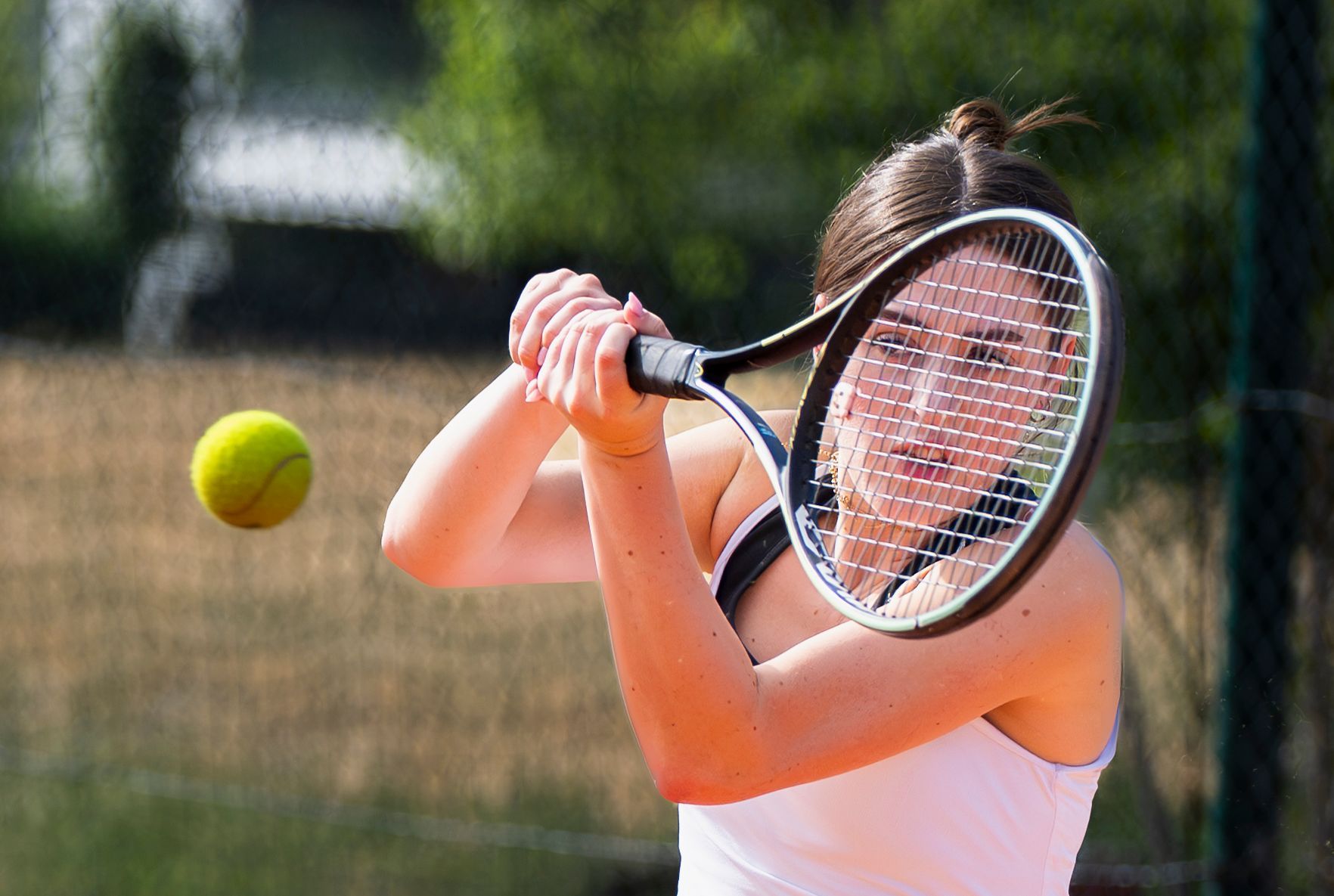 Das Bild zeigt Tennisspielerin Greta Regh bei einer Rückhand.