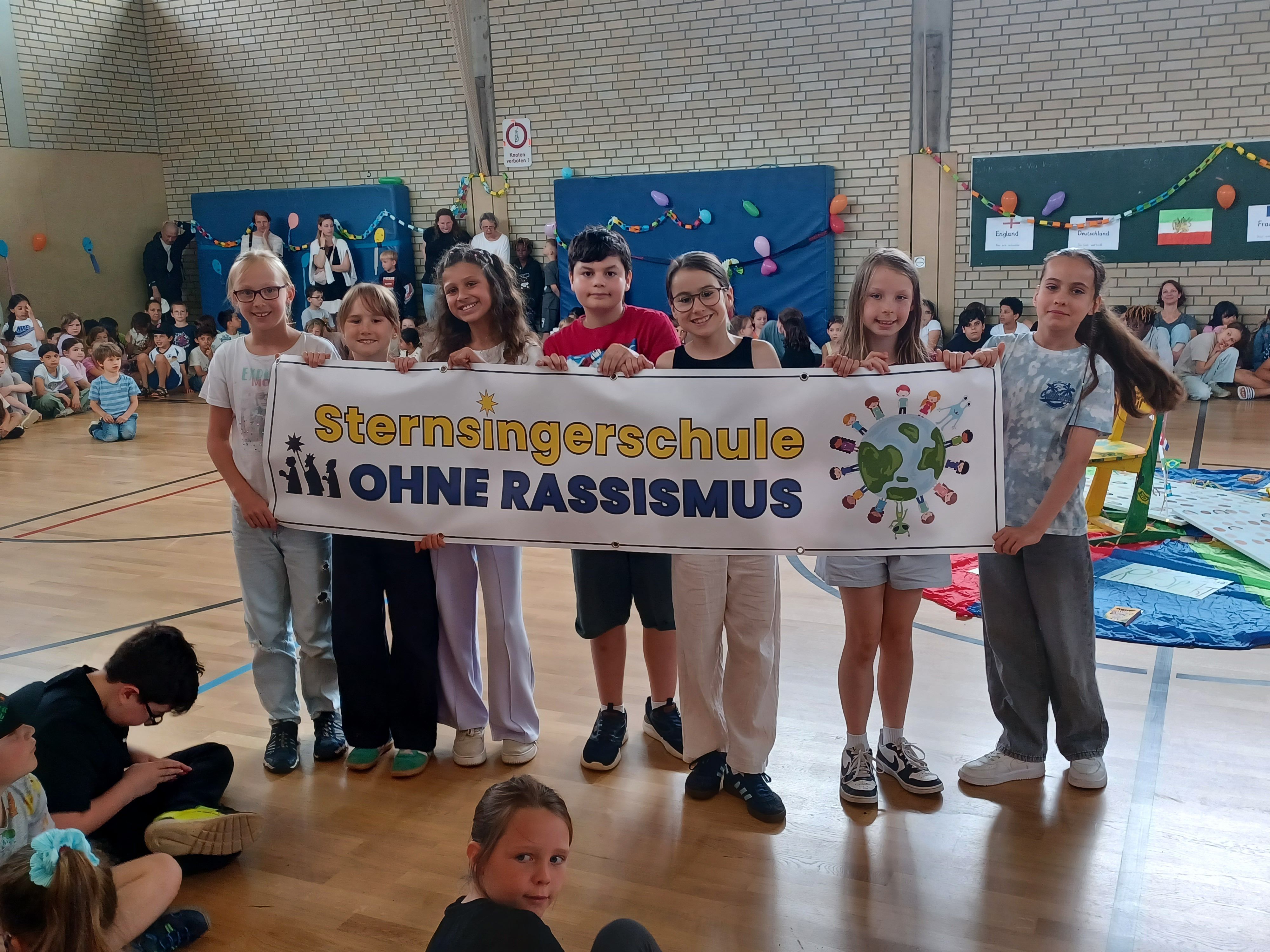 Eine Gruppe von Kindern trägt das Transparent zur Aktion durch die Halle.
