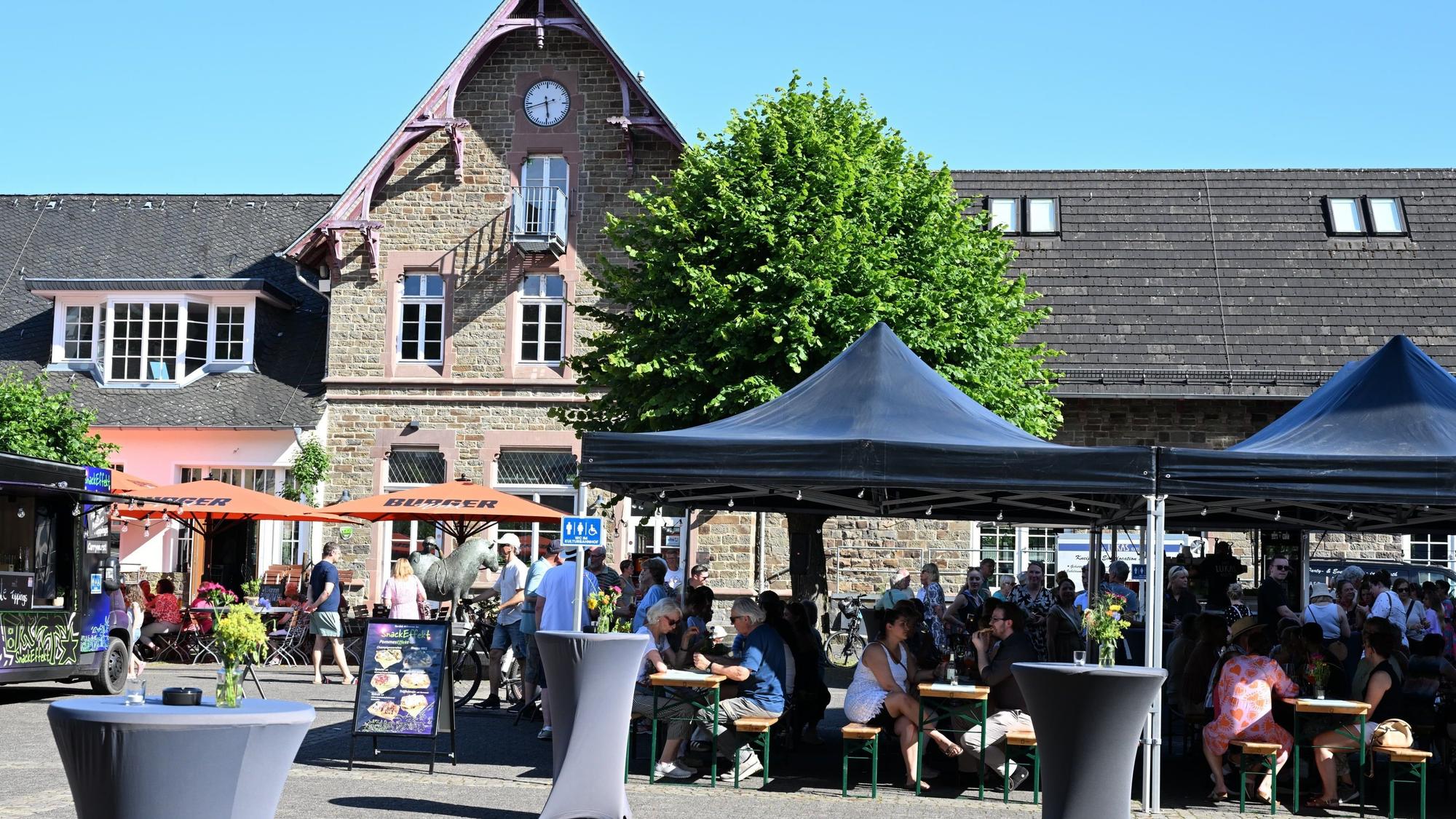 Zu sehen sind einige Pavillons auf einem Platz vor einem alten Gebäude.