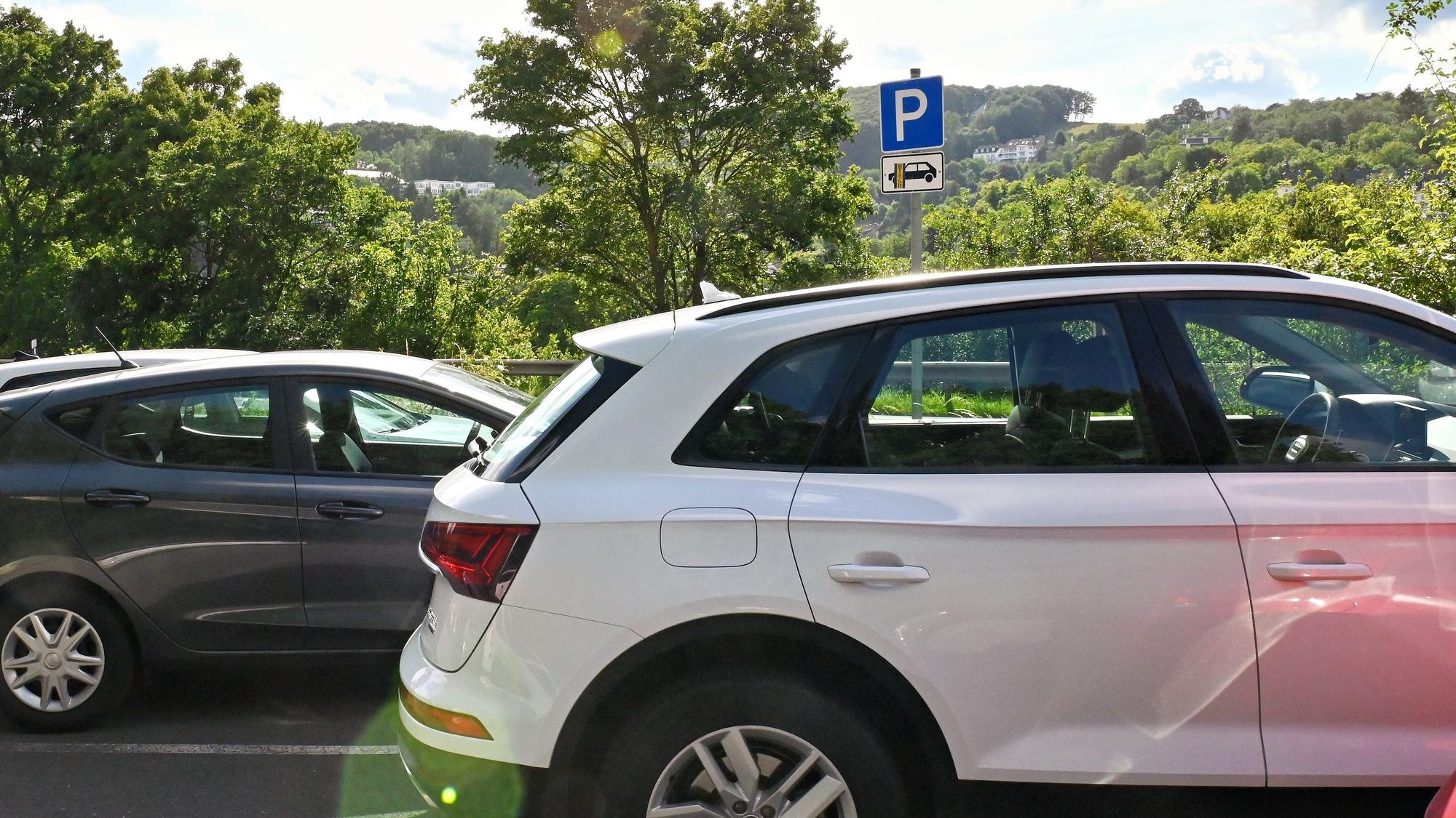 Autos stehen auf einem Parkplatz. Im Hintergrund ist das Parkplatz-Schild mit dem Zusatz-Piktorgramm "nur für Pkw" zu erkennen.