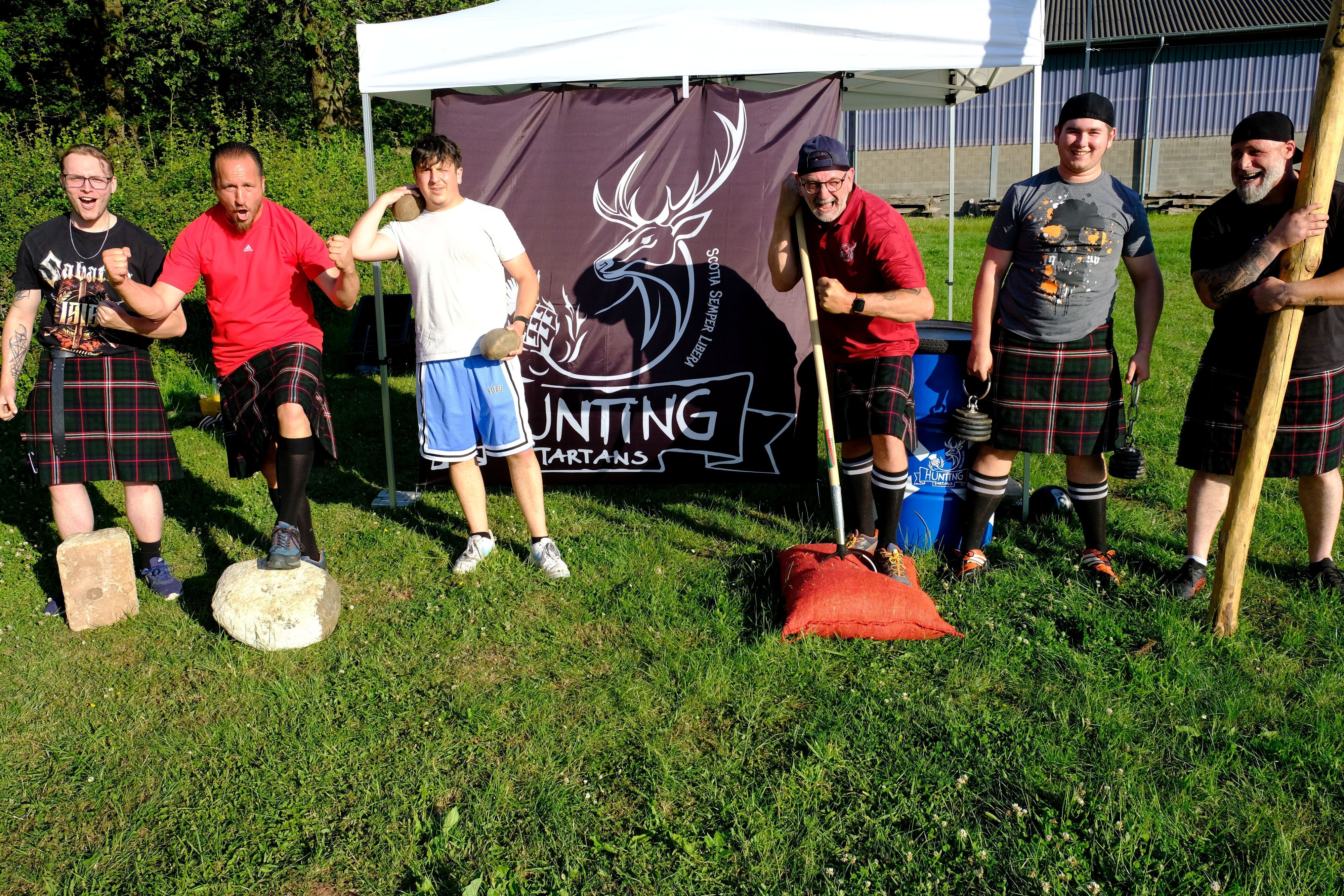 Die Sportler der Hunting Tartans laden auf dem Bolzplatz in Hostel zum Training für die Highland-Games ein. Einige tragen schottische Kilts.