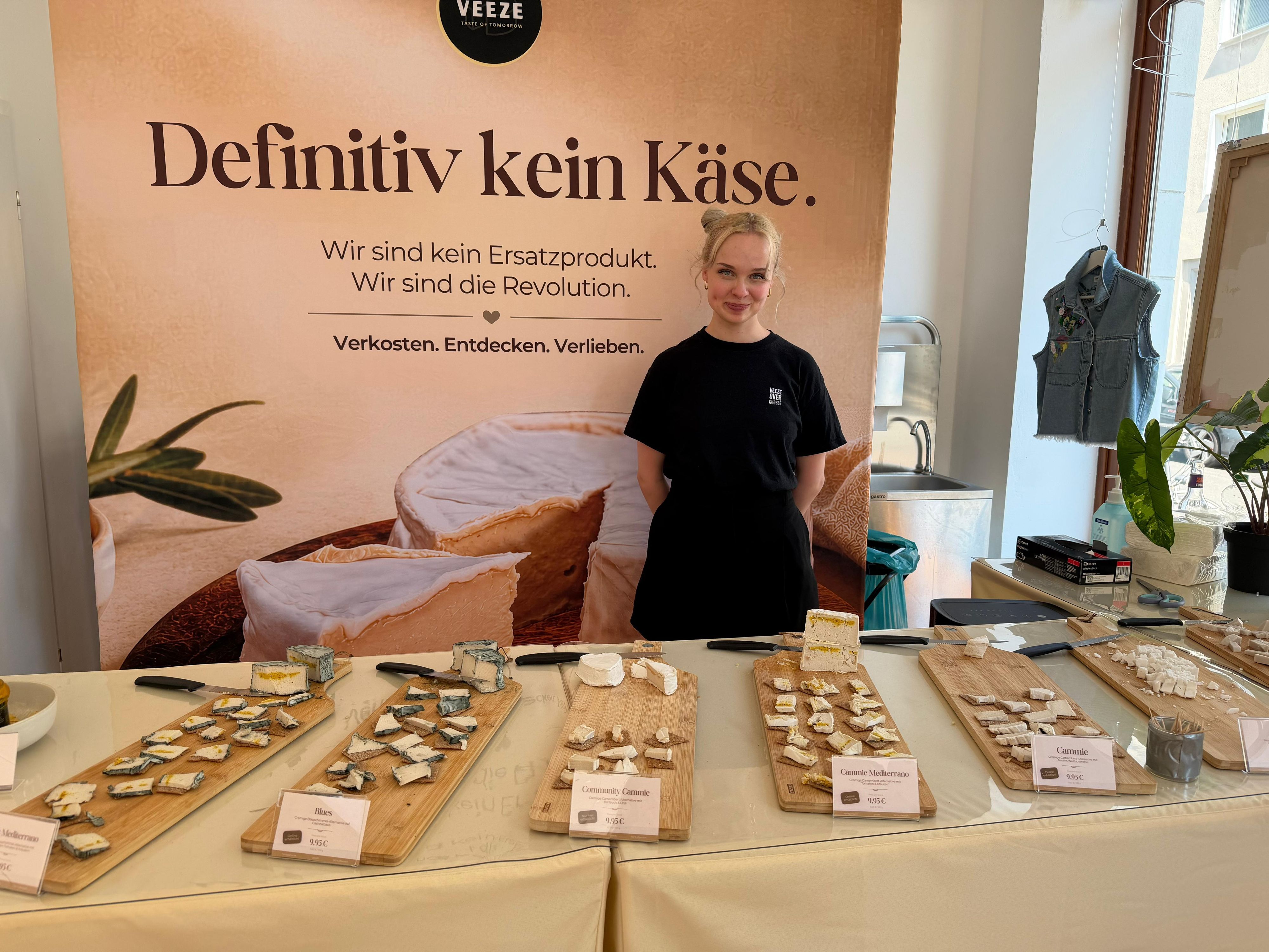 „Veeze“-Gründerin Anna Lessing steht vor einem Tisch mit Käseplatten im Pop-up-Store.