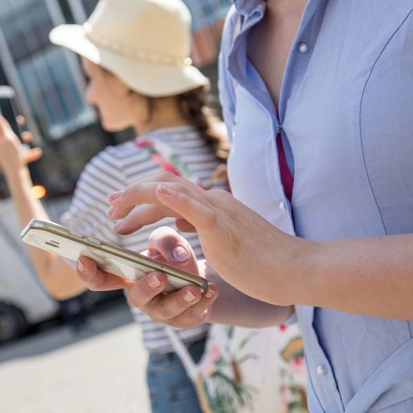 Urlauberinnen schauen auf ihre Smartphones