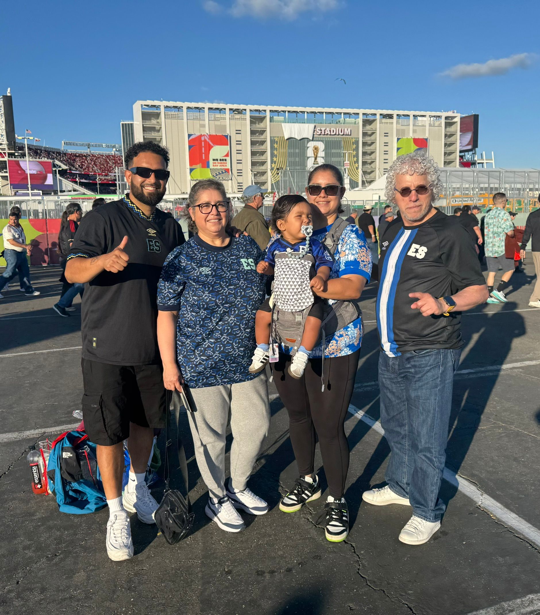 Zwei Männer, zwei Frauen und ein Baby stehen vor einem Stadium in Kalifornien.