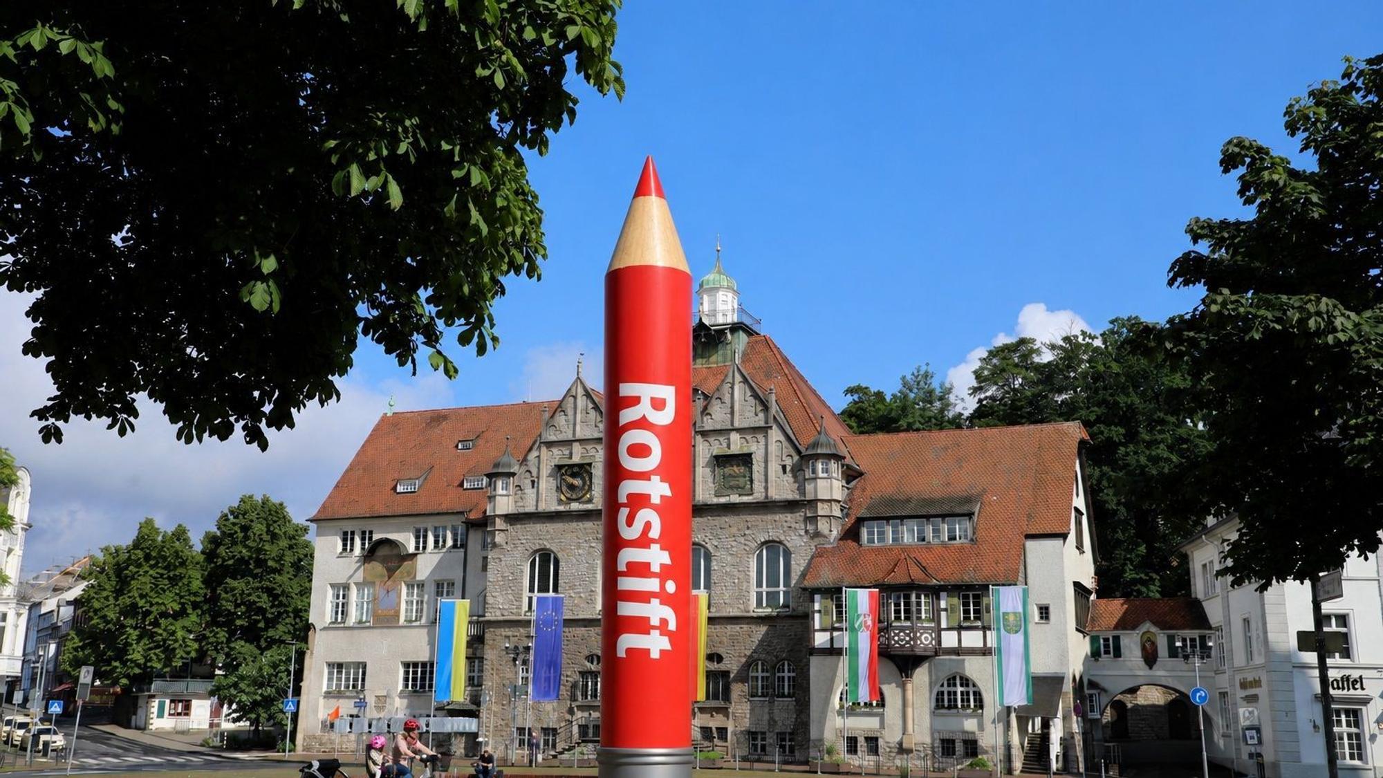 Das Foto zeigt das Gladbacher Rathaus und einen Rotstift