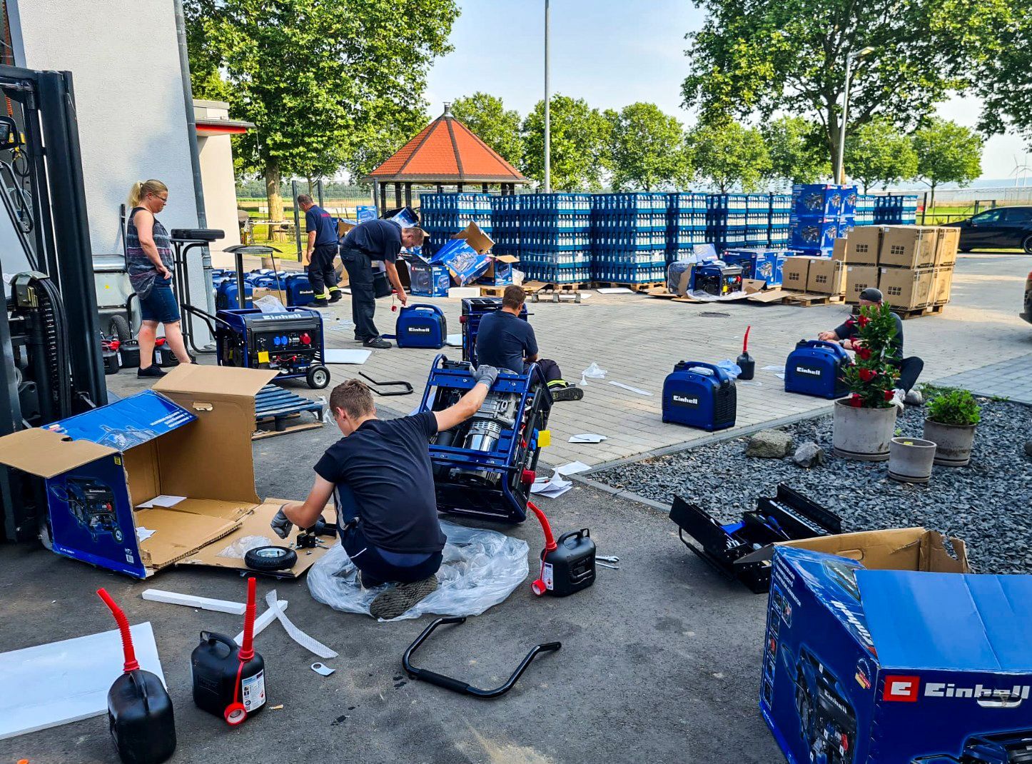 Das Bild zeigt einige Menschen, die Notstromaggregaten zusammenbauen.