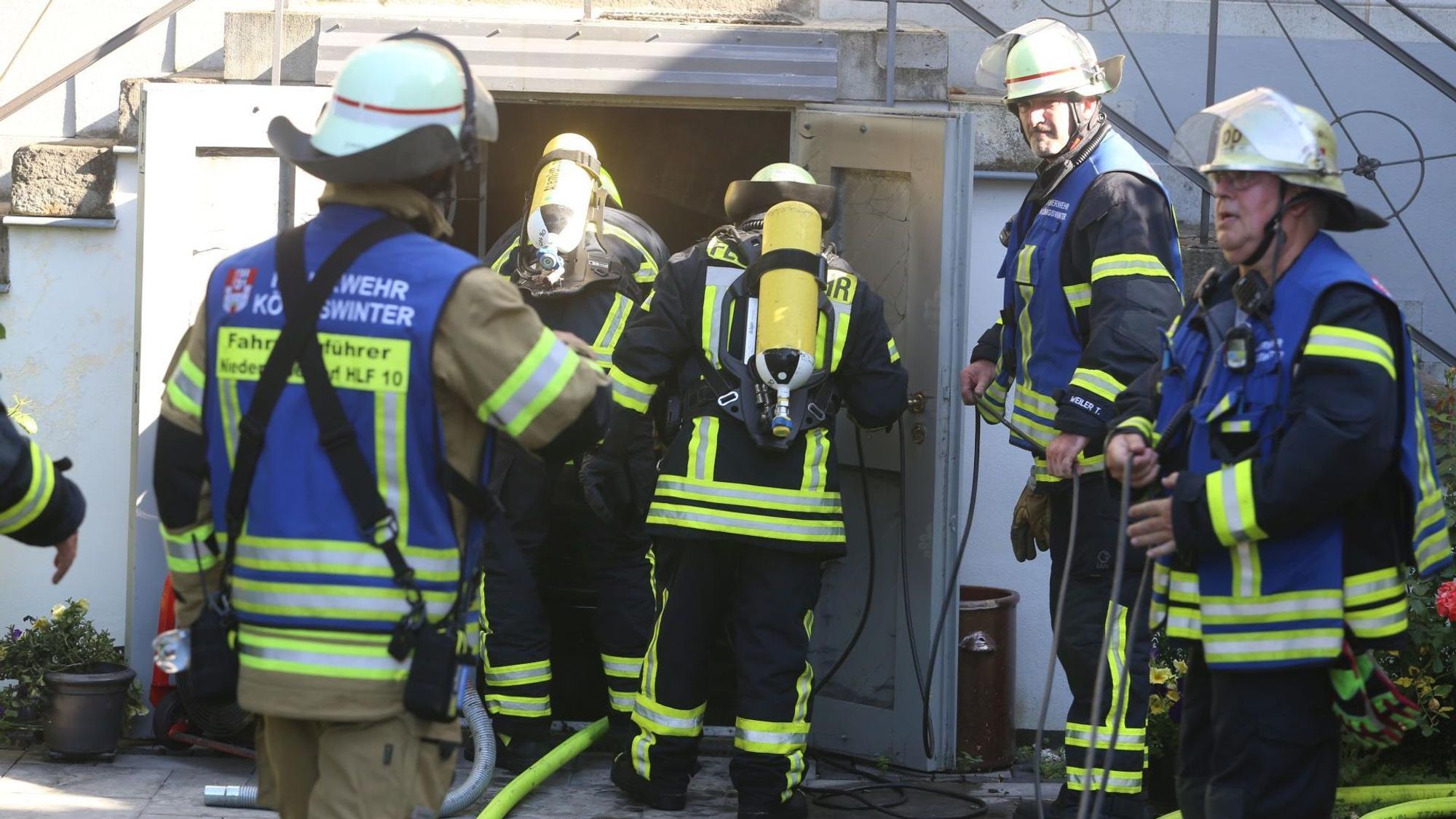 Eine Gruppe von Feuerwehrleuten, zwei von ihnen tragen Atemschutzgeräte.