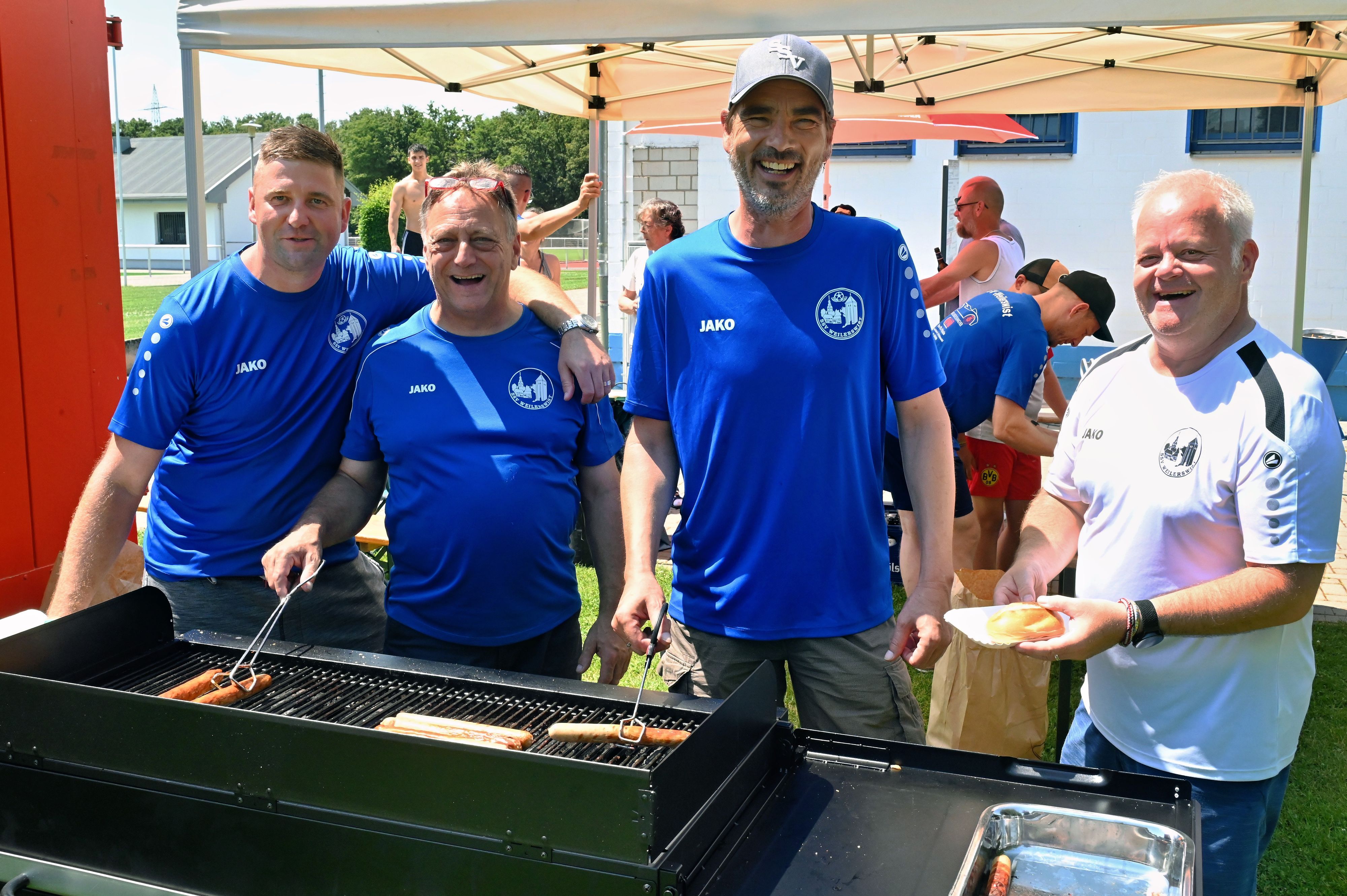 Vier Männer (v.l.: Jugendtrainer Daniel Witt, Jugendtrainer Herbert Gebauer, Geschäftsführer Markus von Elstermann und zweiter Vorsitzender Thomas Damm) stehen am Grill.