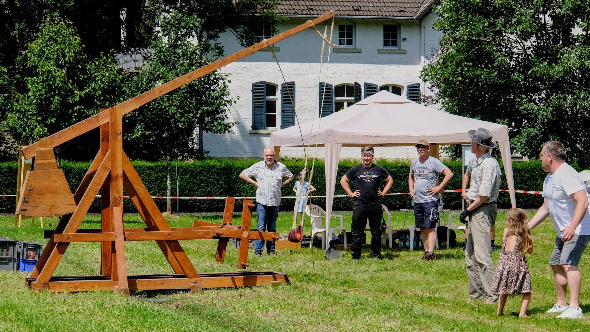 Eine Wurfmaschine aus Holz steht auf Rasen.