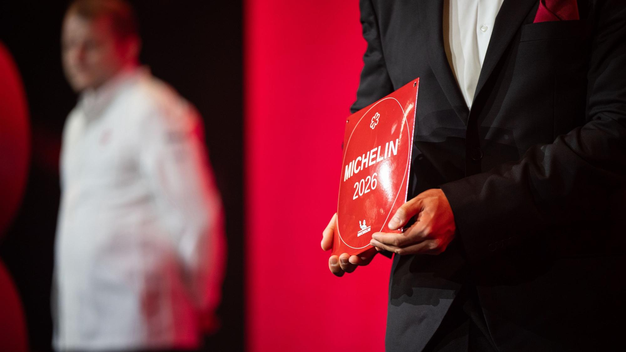 Ein Mitarbeiter hält ein 1-Sterne-Michelin-Schild in den Händen. Mit den Guide-Michelin-Sternen werden jährlich die besten Restaurants Deutschlands ausgezeichnet.
