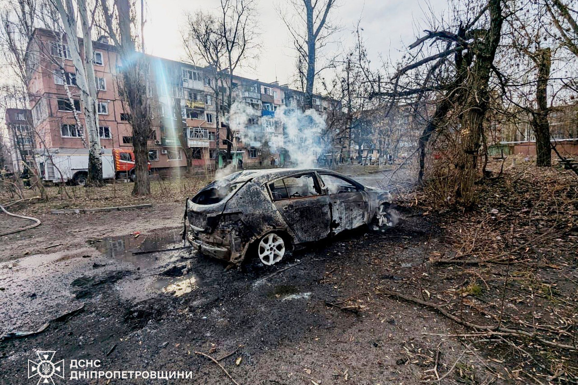 Auf diesem vom ukrainischen Katastrophenschutz zur Verfügung gestellten Foto sind ein verbranntes Auto und beschädigte Wohnhäuser in Krywyj Rih zu sehen, nachdem eine russische Rakete eingeschlagen ist.