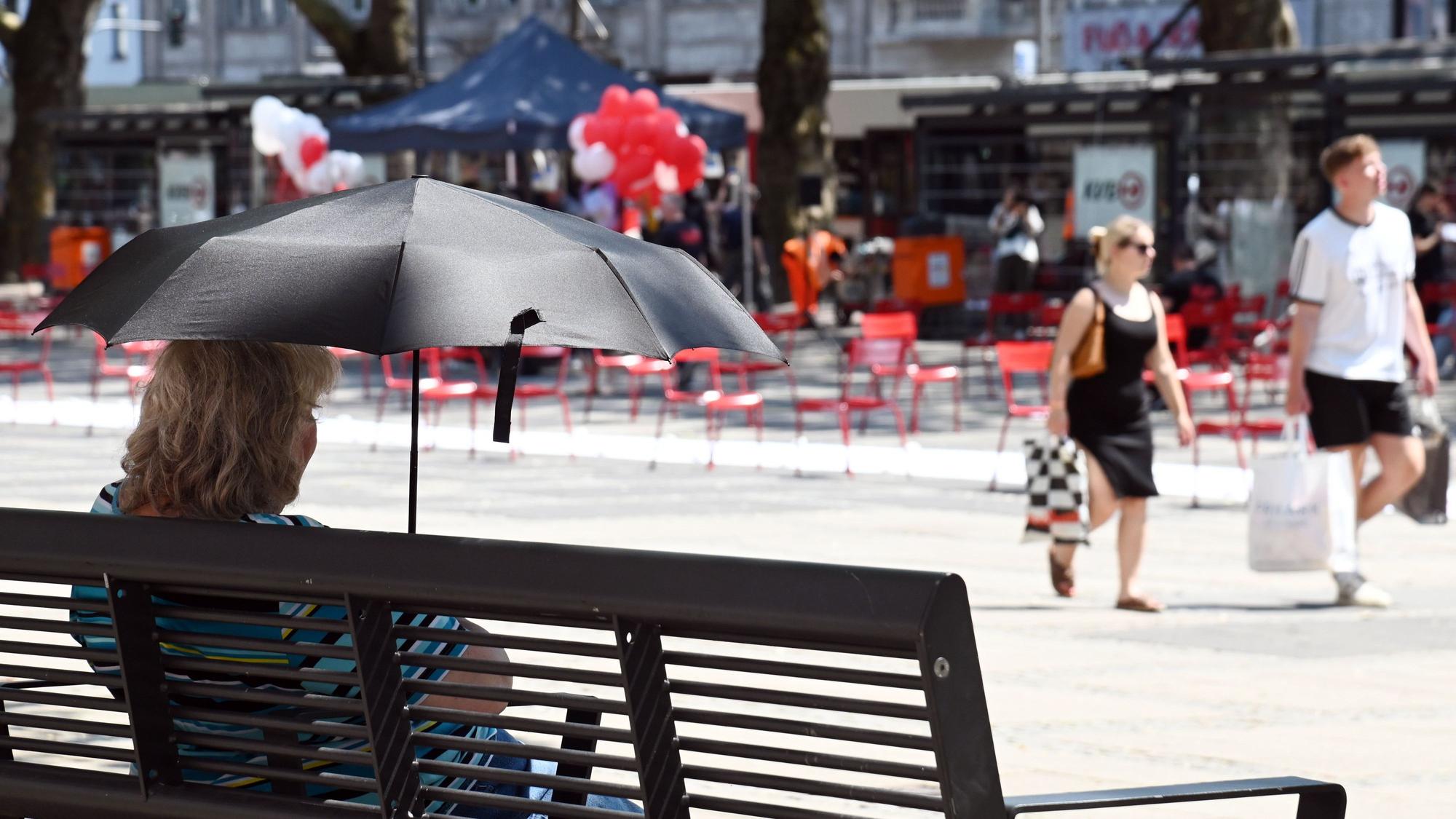 Hitzewelle in Köln: Am Neumarkt suchen die Menschen Abkühlung am Brunnen und im Schatten.