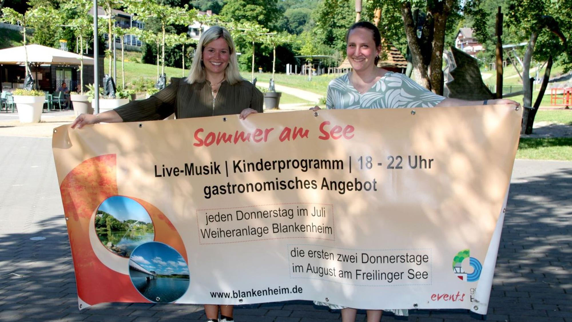 Bürgermeisterin Jennifer Meuren und Touristikerin Janina Bresgen (v.l.) halten ein Veranstaltungsbanner.
