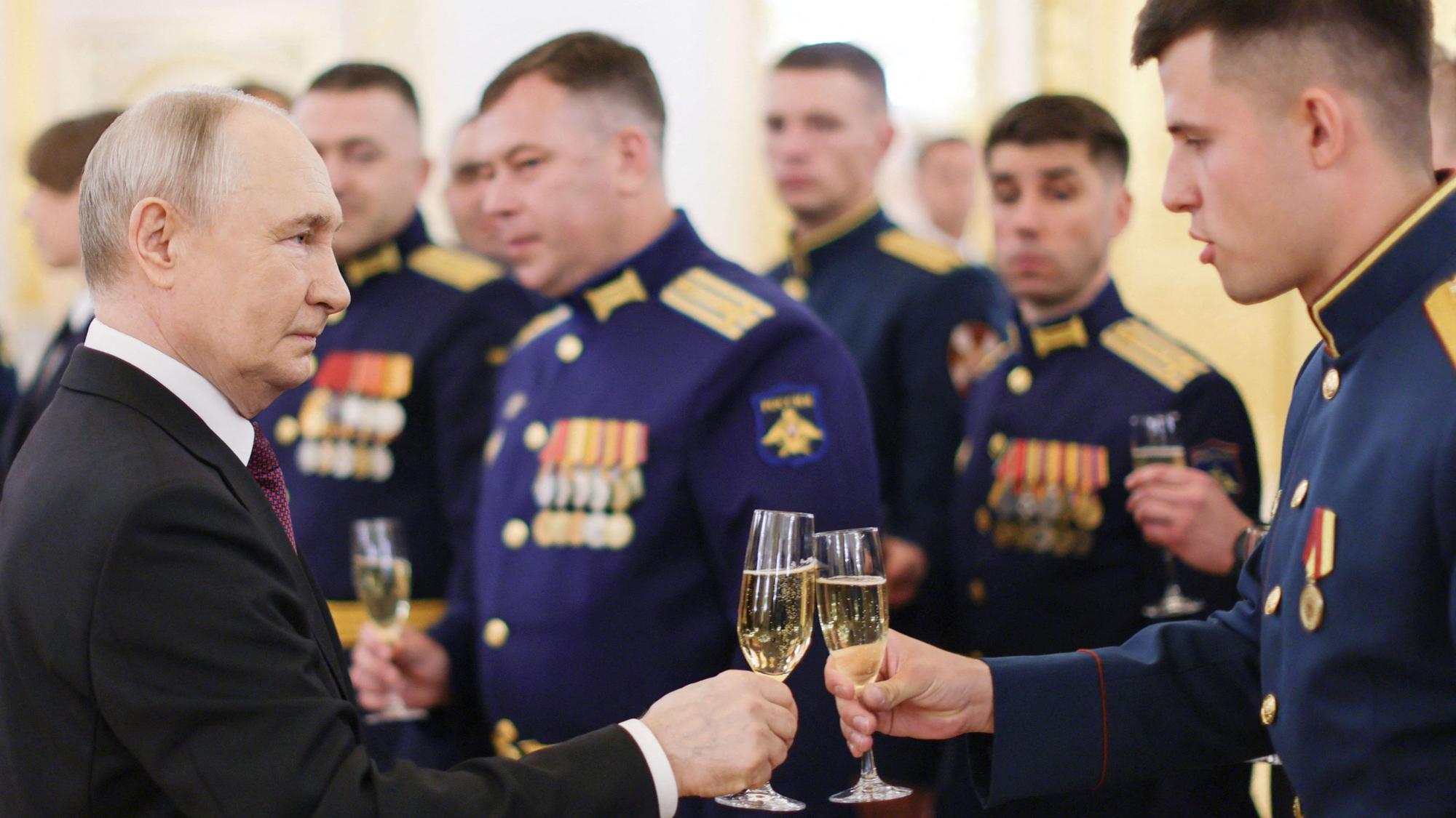 Russlands Präsident Wladimir Putin stößt mit Absolventen der russischen Militärakademien im Kreml an.