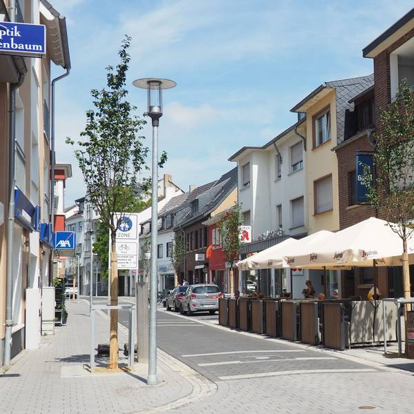 Die Münsterstraße ist mit hellem Pflaster versehen und wird von Bäumen gesäumt.