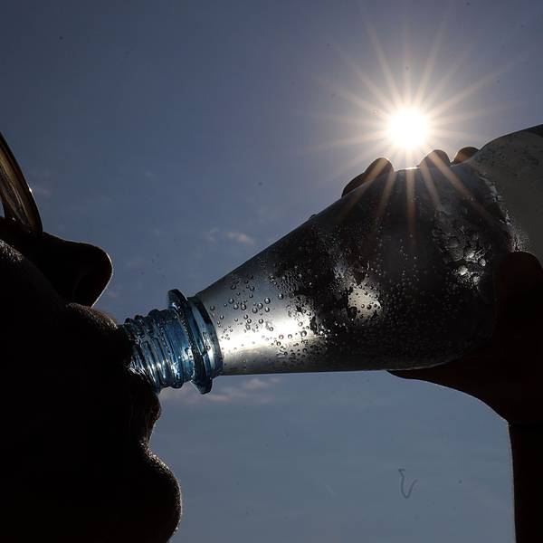 Eine Frau trinkt in Köln in der Sonne Mineralwasser. (Archivbild)