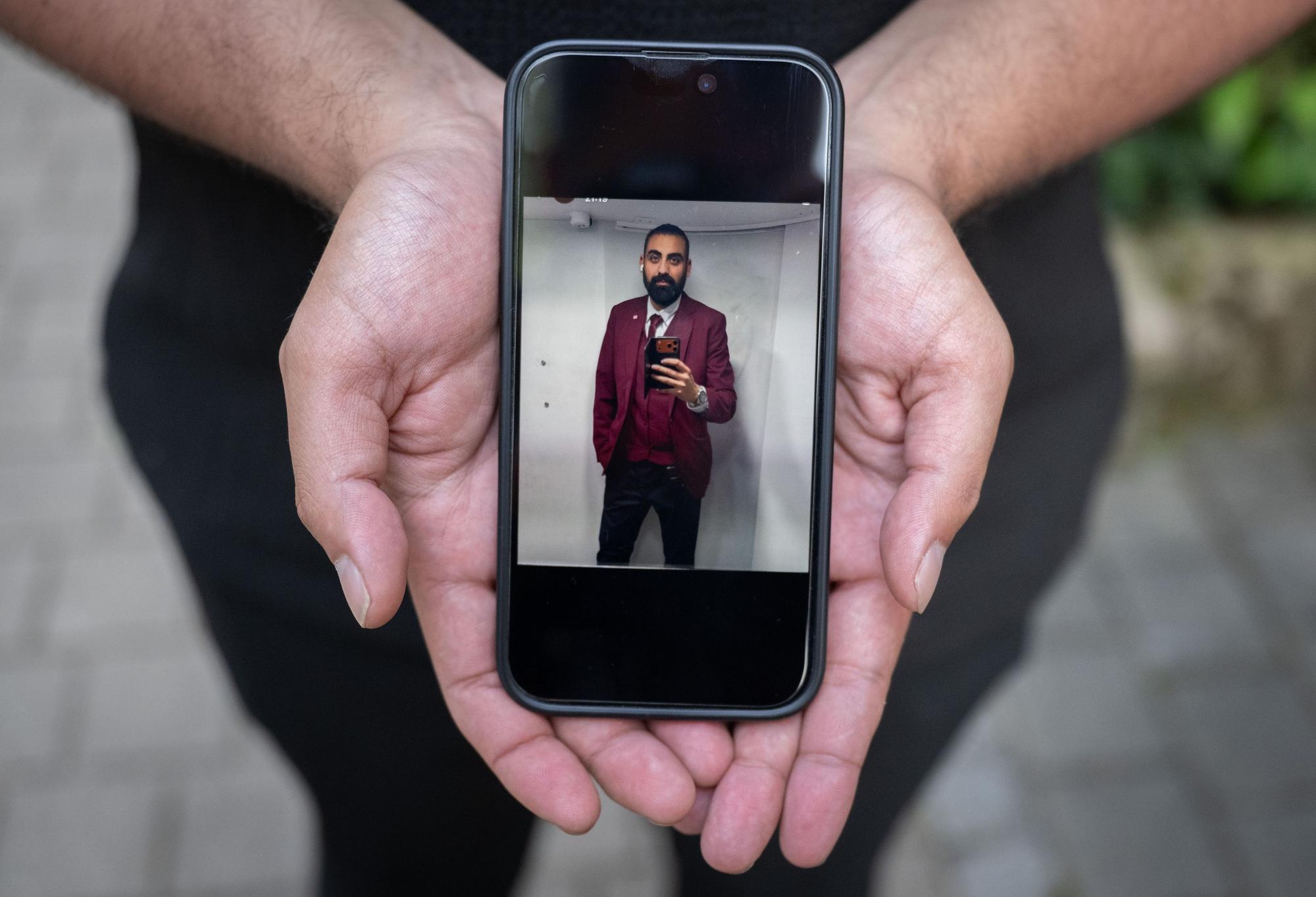 22.06.2026, Baden-Württemberg, Mannheim: Eray Calar zeigt auf seinem Handy ein Foto seines getöteten Bruders Serkan Calar. Das Selfie zeigt den Zugbegleiter am Morgen seines Todes. Der Angestellte der Deutschen Bahn war im Februar 2026 während einer Fahrkartenkontrolle in einem Regionalexpress von einem Fahrgast angegriffen worden und später an seinen Verletzungen gestorben. (zu dpa: «Familie von getötetem Zugbegleiter will Gerechtigkeit») Foto: Boris Roessler/dpa +++ dpa-Bildfunk +++