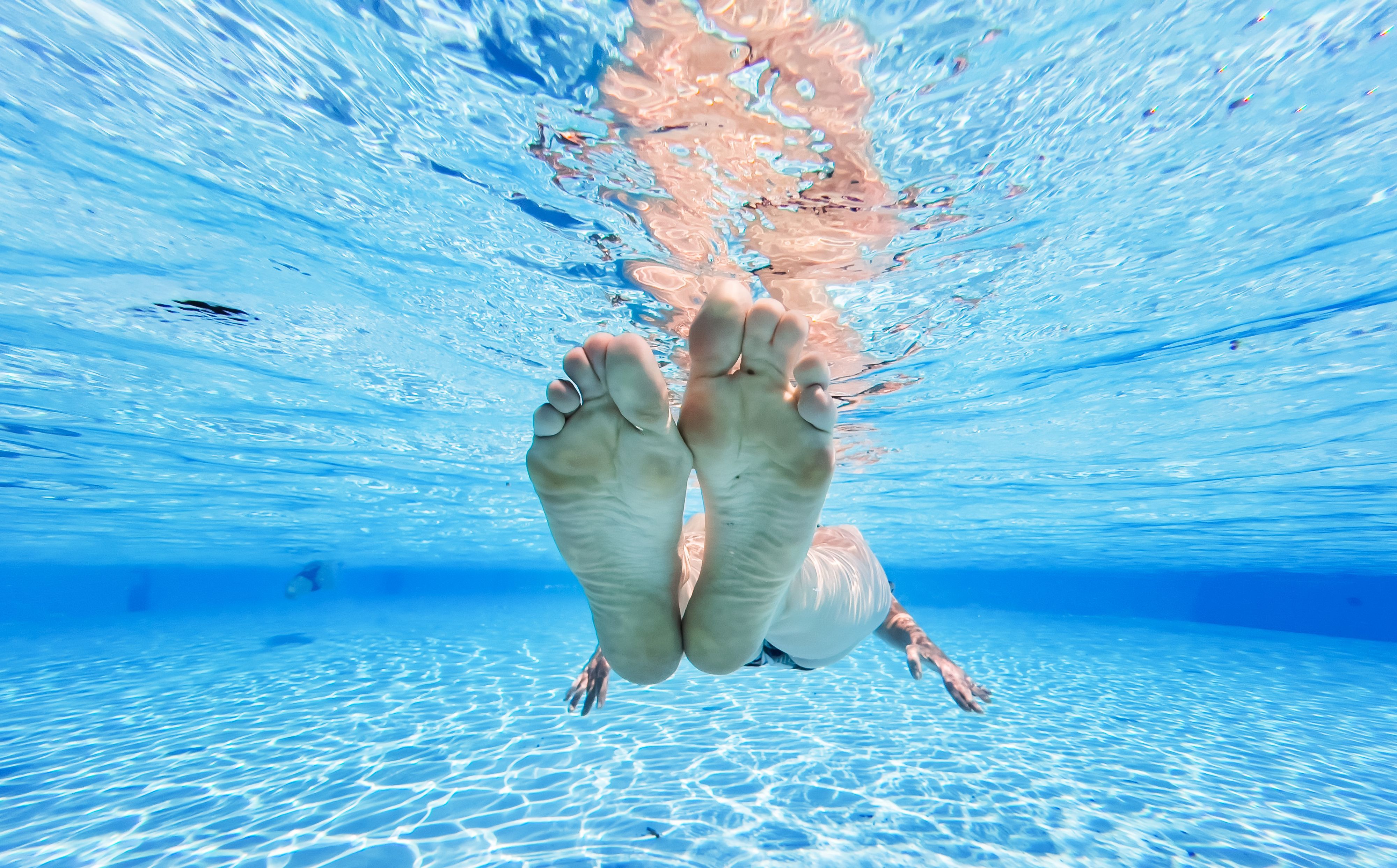Eine Frau treibt im kühlen Wasser eines Pools. (Symbolbild)