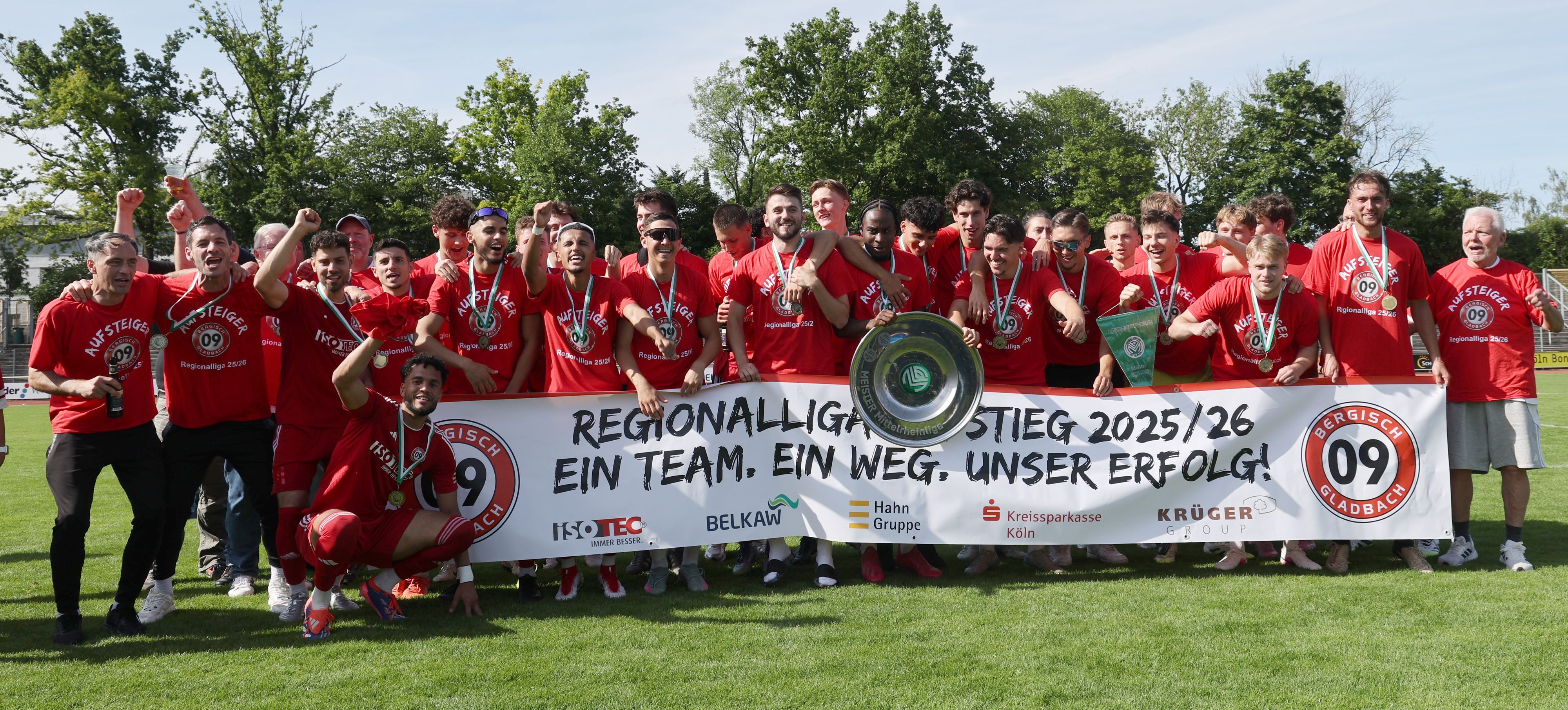 Die Mannschaft jubelt mit einem Banner über den Aufstieg