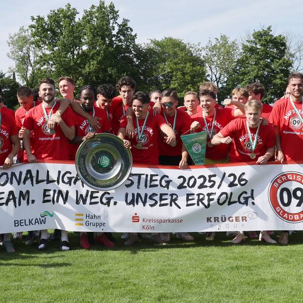 Die Mannschaft jubelt mit einem Banner über den Aufstieg