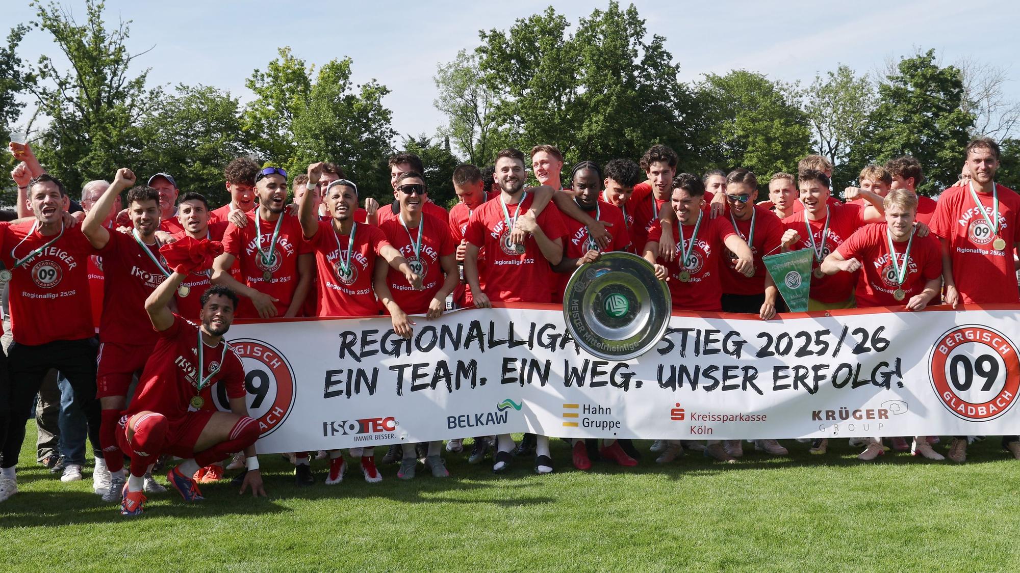 Die Mannschaft jubelt mit einem Banner über den Aufstieg