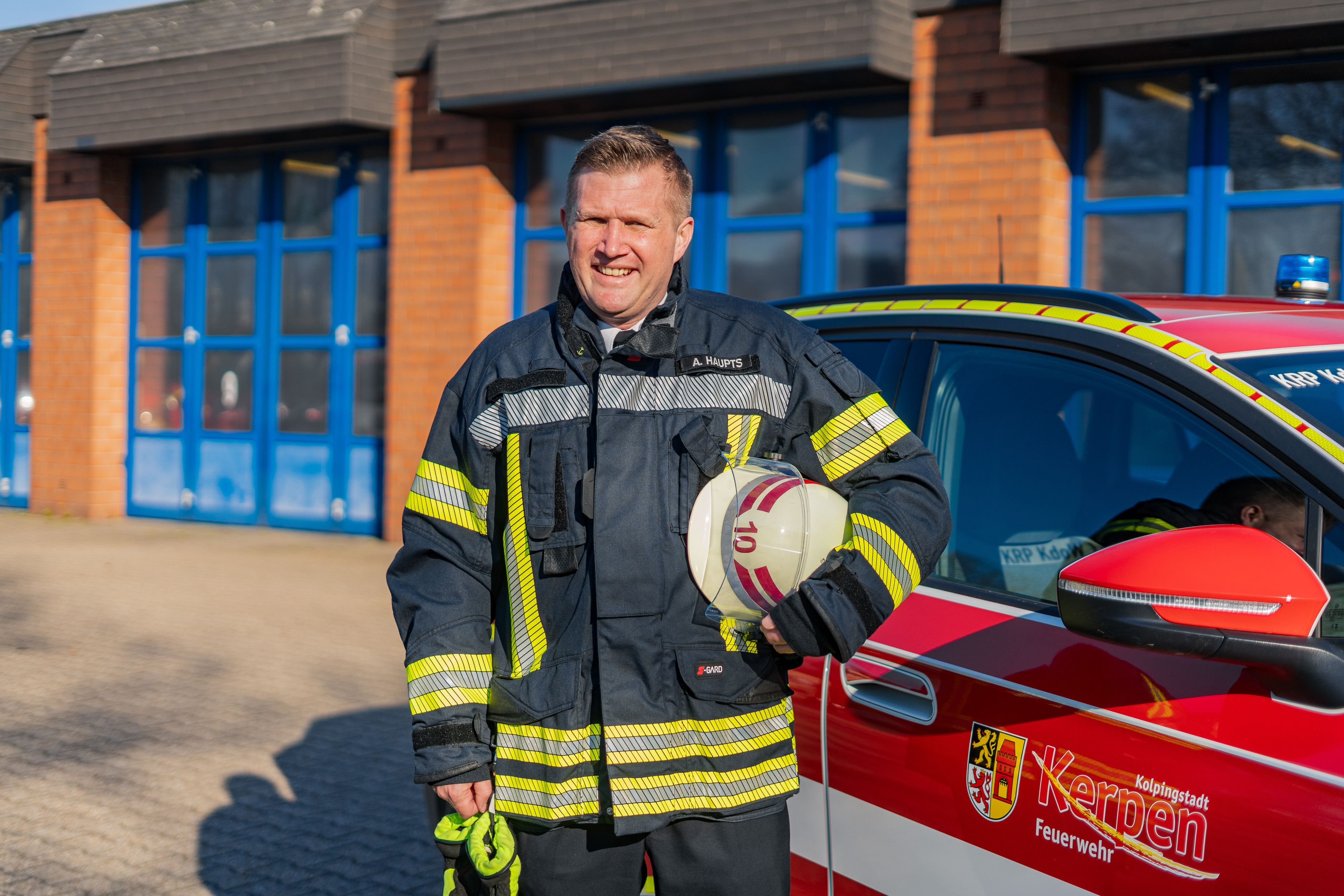 Das Foto zeigt einen Feuerwehrmann mit Helm in der Hand.