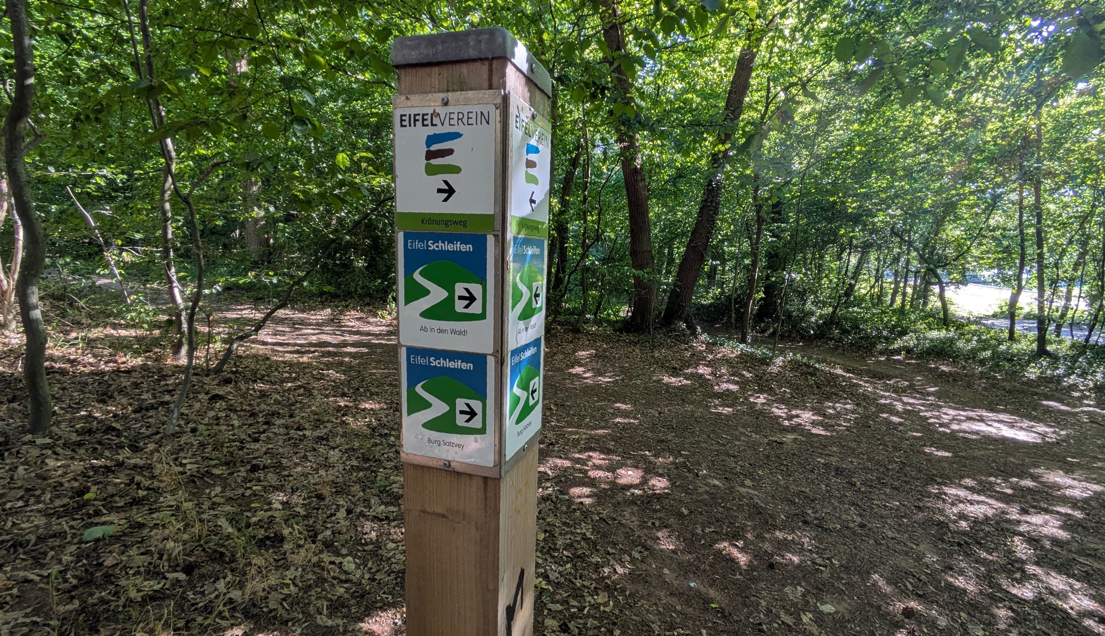 Wanderwegweiser an der Eifelschleife„ Ab in den Wald“ in der Nähe der Katzensteine.