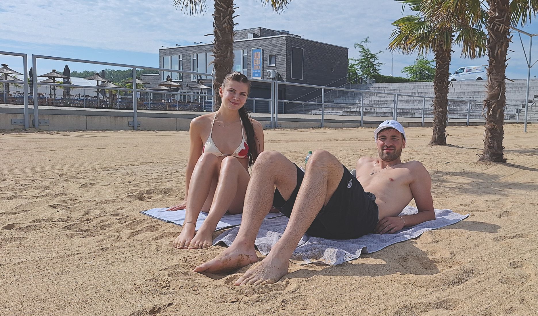 Ein Paar liegt am Sandstrand.
