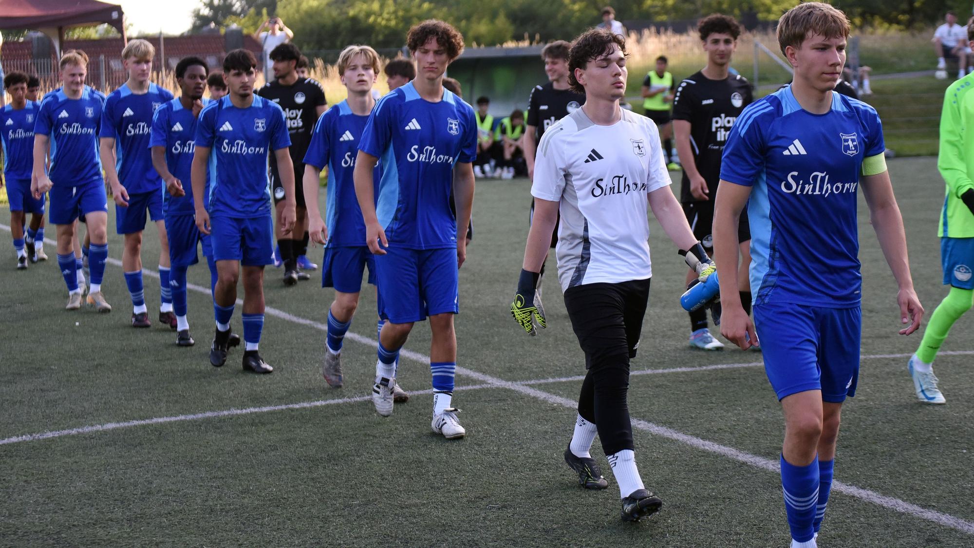 Zwei Fußballmannschaften betreten das Spielfeld.