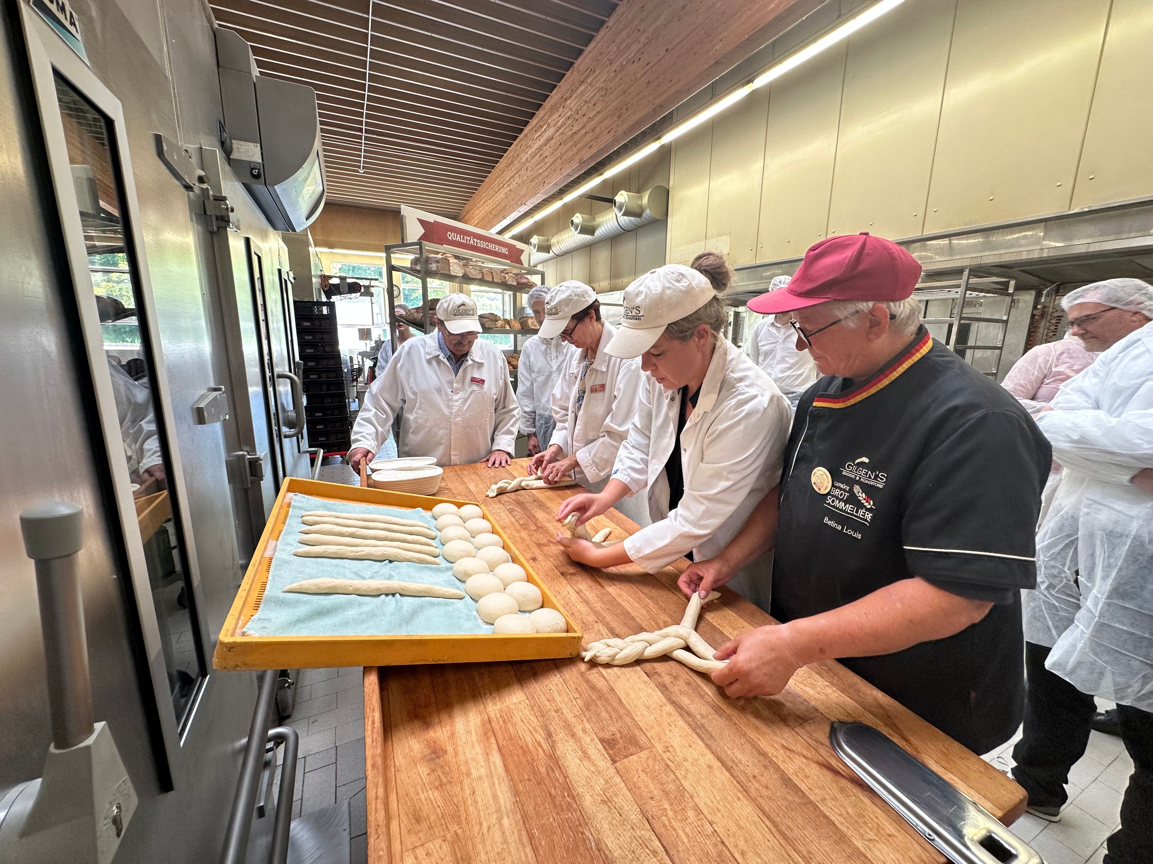 Ministerin Mona Neubaur (2.v.r) zu Besuch bei Gilgens in Hennef. Dort bereitete sie einen Hefezopf zu. Brot-Someliere Betina Louis (r.)  und Manuela Gilgen (3.v.r.)  standen mit am Backtisch. Bäckermeister Franz-Josef Gilgen (l.) gab den einen oder anderen Tipp.
