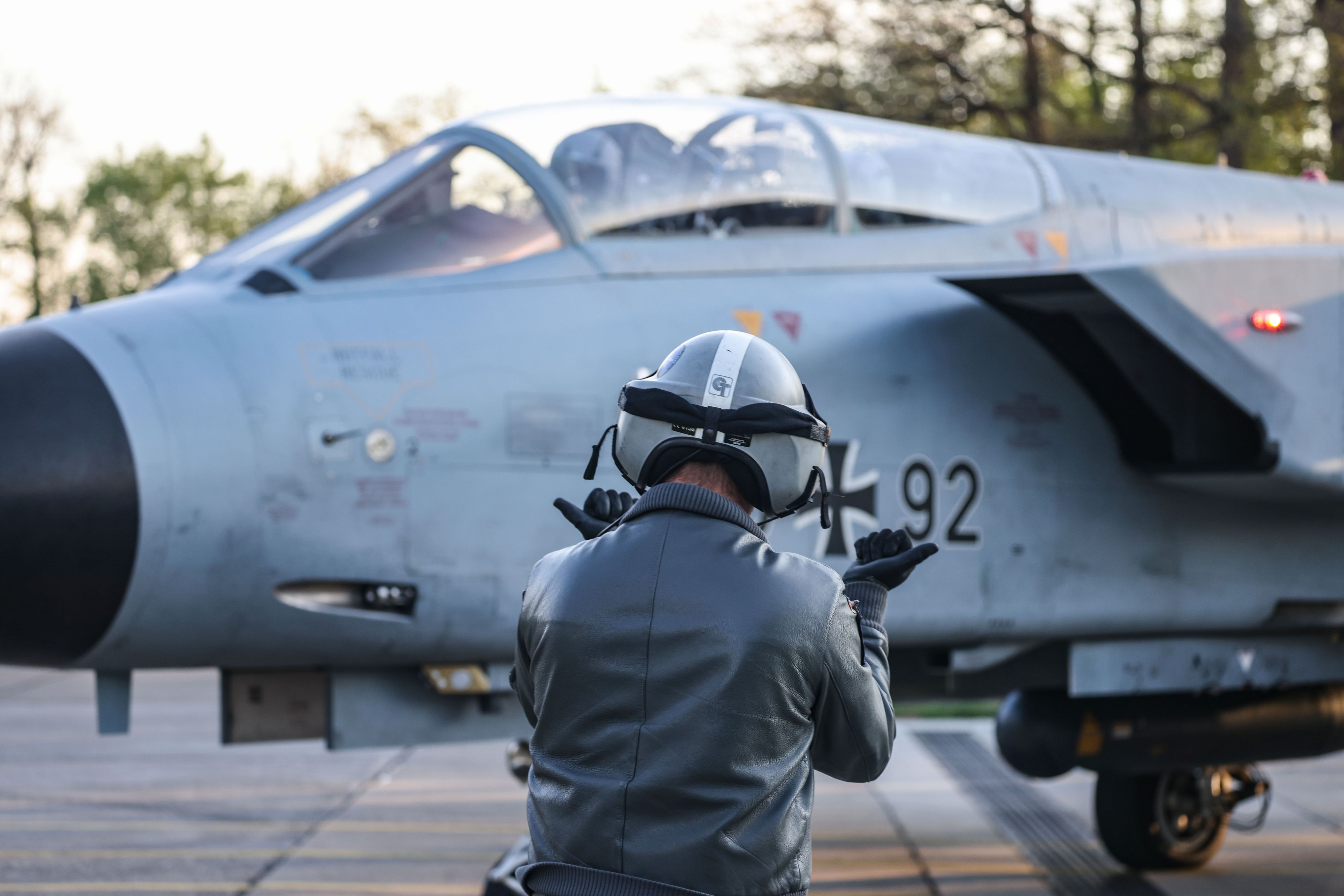 Auf dem Foto zu sehen ist ein Mann von hinten, der vor einem Tornado-Jet steht.