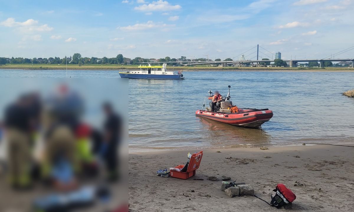 Rettungskräfte versorgen eine Person am Rheinufer in Düsseldorf.