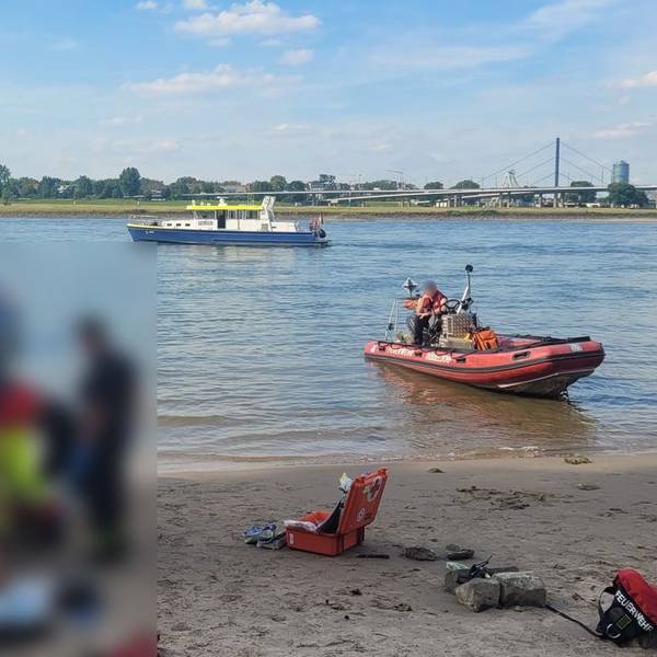 Rettungskräfte versorgen eine Person am Rheinufer in Düsseldorf.