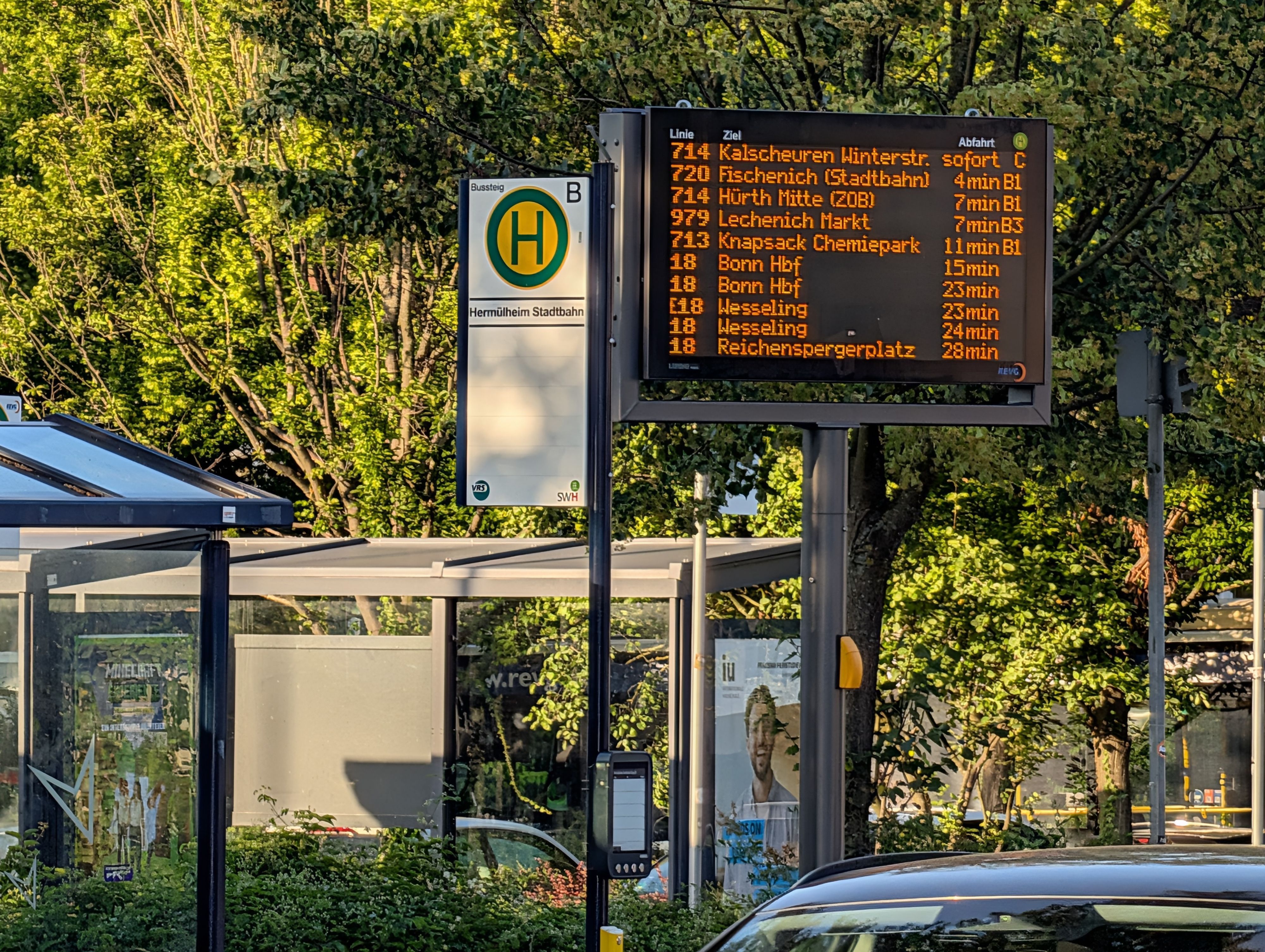 Das Foto zeigt die Haltestellenfahne neben der Fahrgastinfotafel.