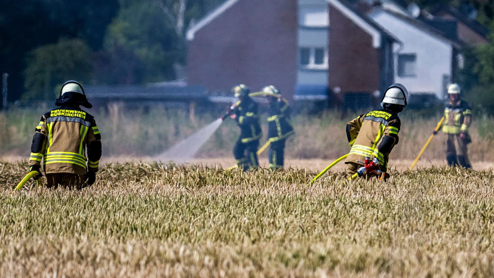 Das Bild zeigt Feuerwehrleute, die löschen. Und welche, die sich auf dem Weg zum Einsatzort befinden.
