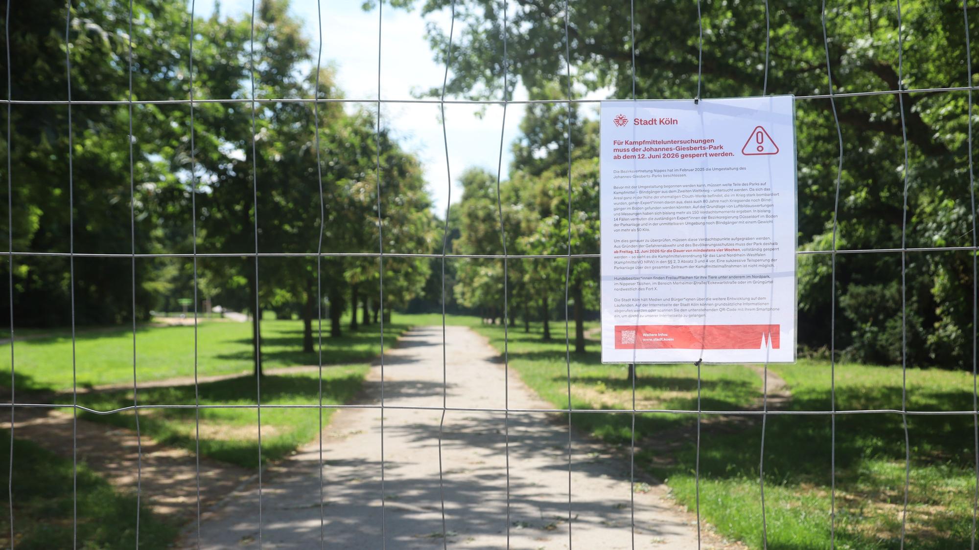 23.06.2026, Köln: Ein Schild der Stadt Köln informiert an einem Bauzaun über die Sperrung des Johannes-Giesberts-Parks für Kampfmitteluntersuchungen. Der Park bleibt während der Arbeiten für Besucher geschlossen. Foto: Arton Krasniqi