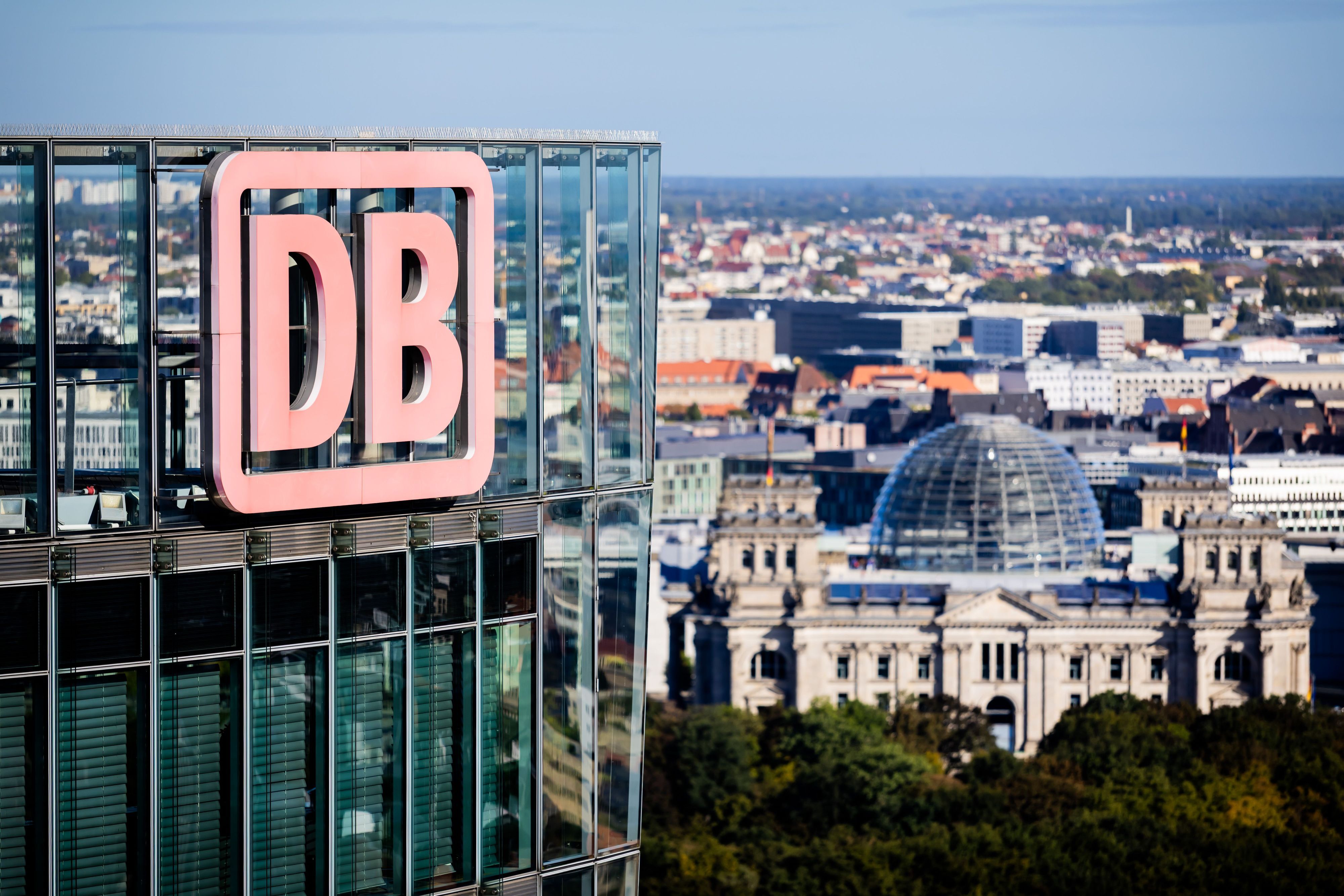 ARCHIV - 23.09.2025, Berlin: Das DB-Logo am Bahntower, Sitz der Dachgesellschaft der Deutschen Bahn, aufgenommen während einer Aufsichtsratssitzung der Deutschen Bahn, im Hintergrund das Reichstagsgebäude.  (zu dpa: «Michael Obrowski wird neuer Finanzvorstand der Bahn») Foto: Christoph Soeder/dpa +++ dpa-Bildfunk +++