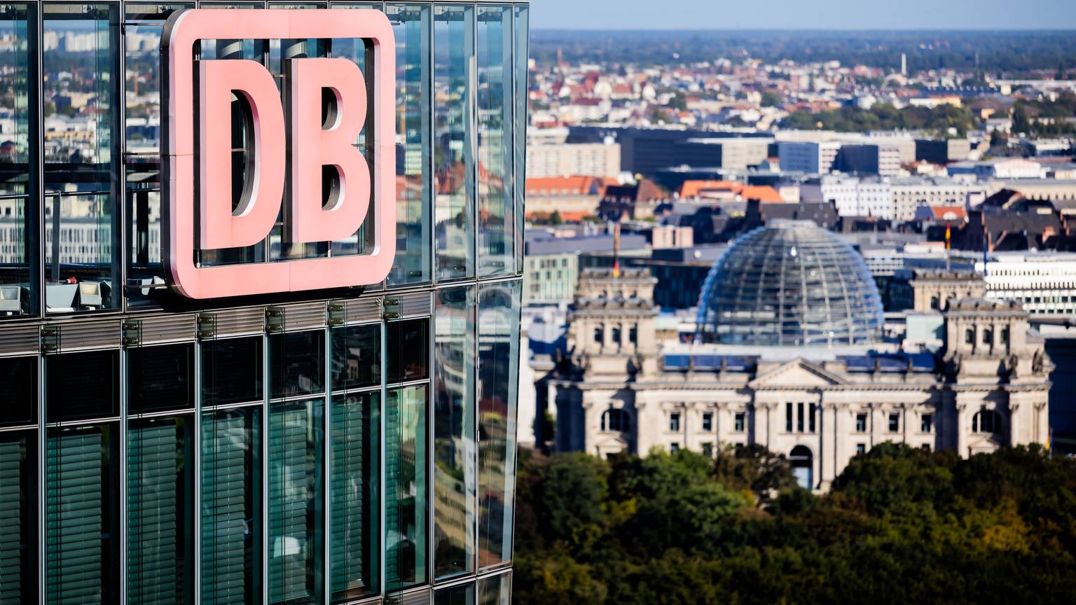 ARCHIV - 23.09.2025, Berlin: Das DB-Logo am Bahntower, Sitz der Dachgesellschaft der Deutschen Bahn, aufgenommen während einer Aufsichtsratssitzung der Deutschen Bahn, im Hintergrund das Reichstagsgebäude. (zu dpa: «Michael Obrowski wird neuer Finanzvorstand der Bahn») Foto: Christoph Soeder/dpa +++ dpa-Bildfunk +++