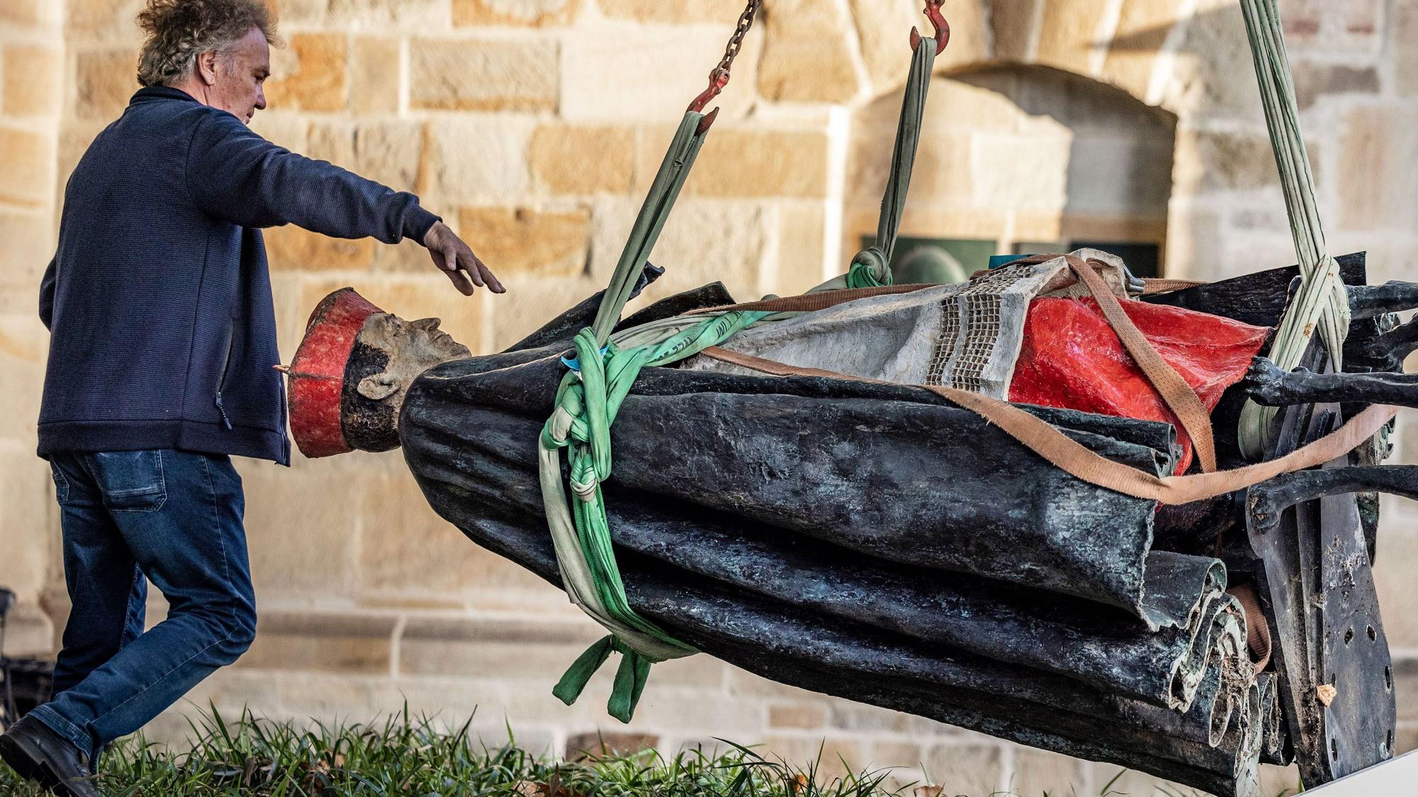 25.09.2023, Nordrhein-Westfalen, Essen: Die Skulptur des Essener Kardinals Franz Hengsbach hängt nach der Demontage vor dem Essener Dom an einem Kran und wird verladen. Das Bistum Essen hatte mitgeteilt, dass der «gravierende» Verdacht bestehe, Hengsbach könnte in seiner Zeit als Weihbischof in Paderborn eine 16-Jährige sexuell missbraucht haben.