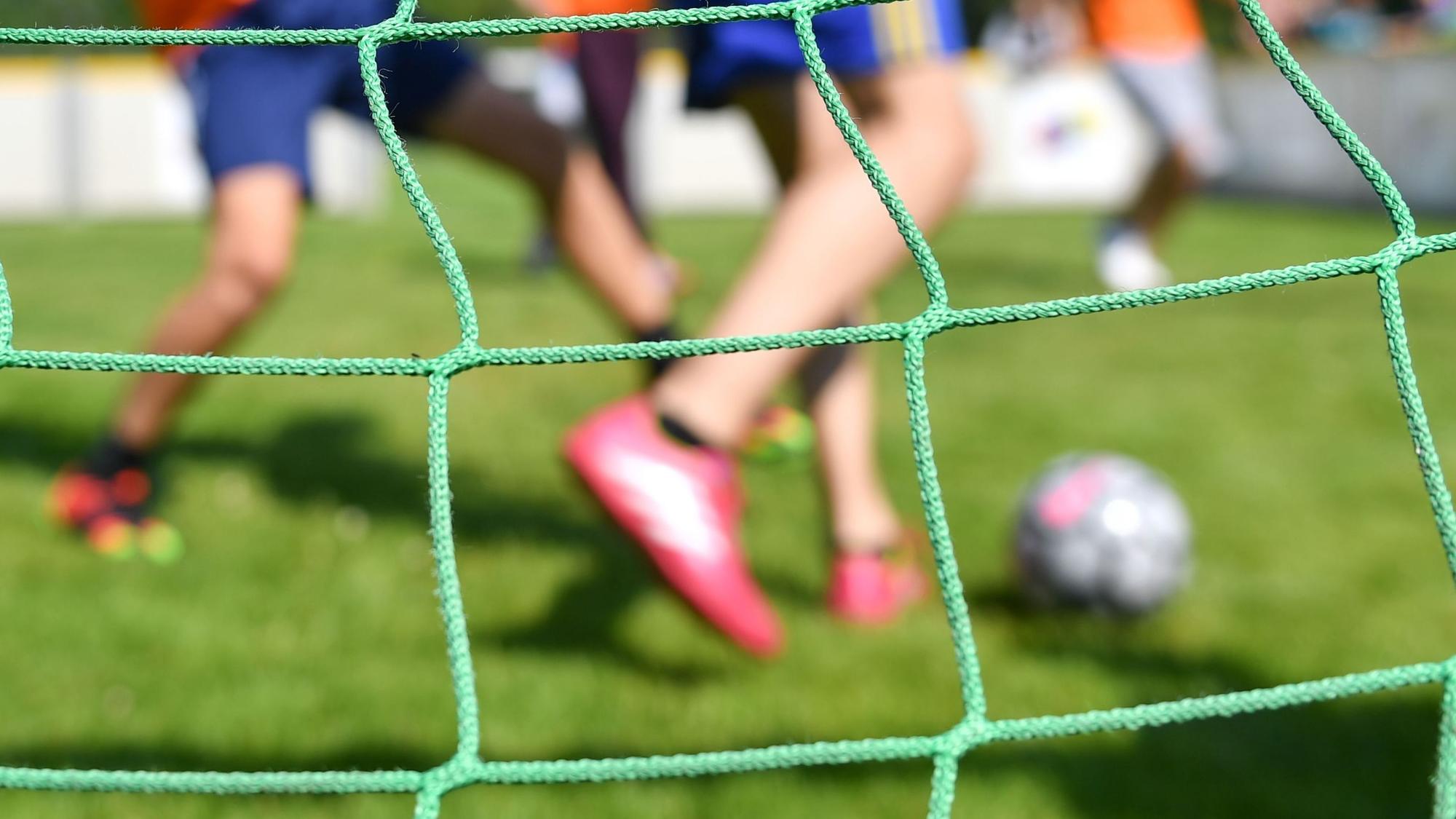 Kinder spielen auf einem Kleinfeld Fußball.